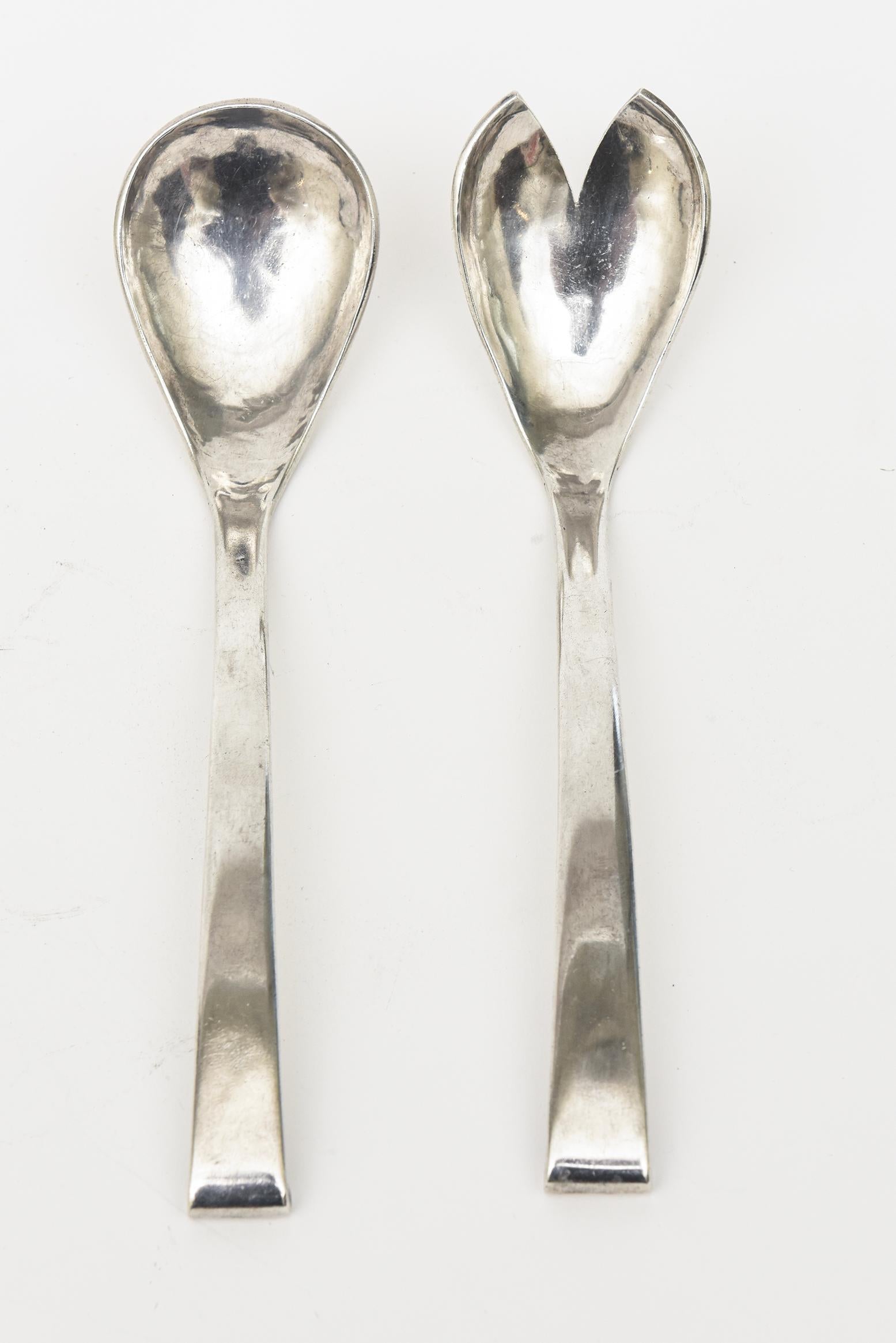 This pair of vintage sterling silver hallmarked salad servers or serving pieces are very modernist in design. They were made in Peru from the time. They have a curved bend and give it height as the fork and spoon. The hallmarks are 