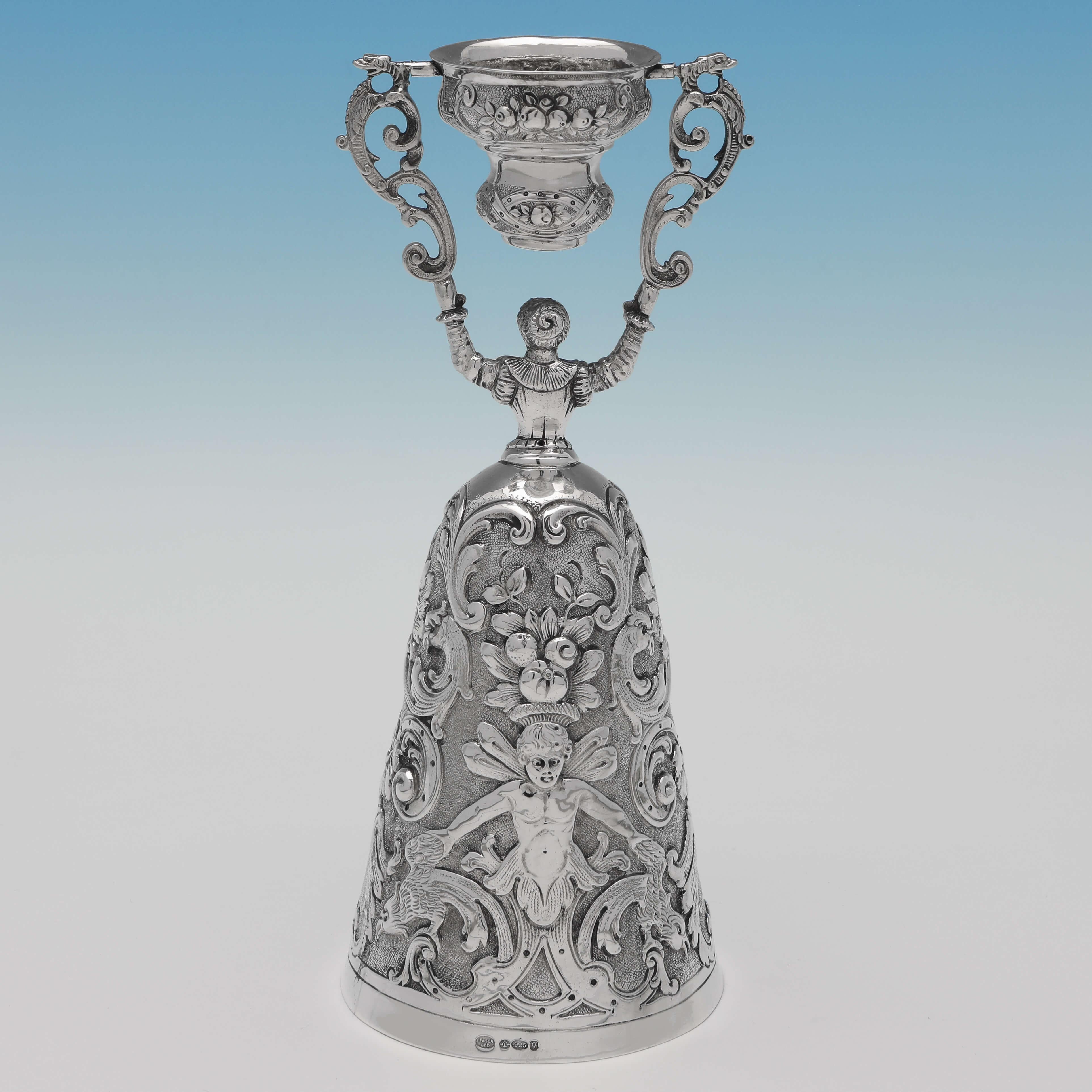 Carrying import marks for London in 1962 by I. Freeman & Sons, this striking, Sterling Silver Wager Cup, is modelled as a lady in costume, and features chased decoration throughout. The wager cup measures 8