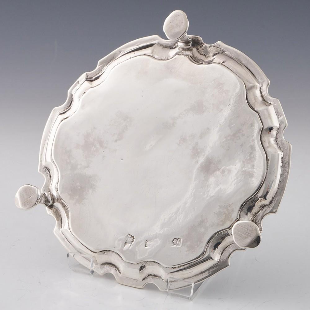 Heading : Sterling silver waiter. 
Date : Hallmarked in London c1740 for Thomas England
Period : George II
Origin : London, England
Decoration : Scalloped rim, chased border with scallop shells, fleur de lys, and scrolling. Three hoofed feet.
Size :