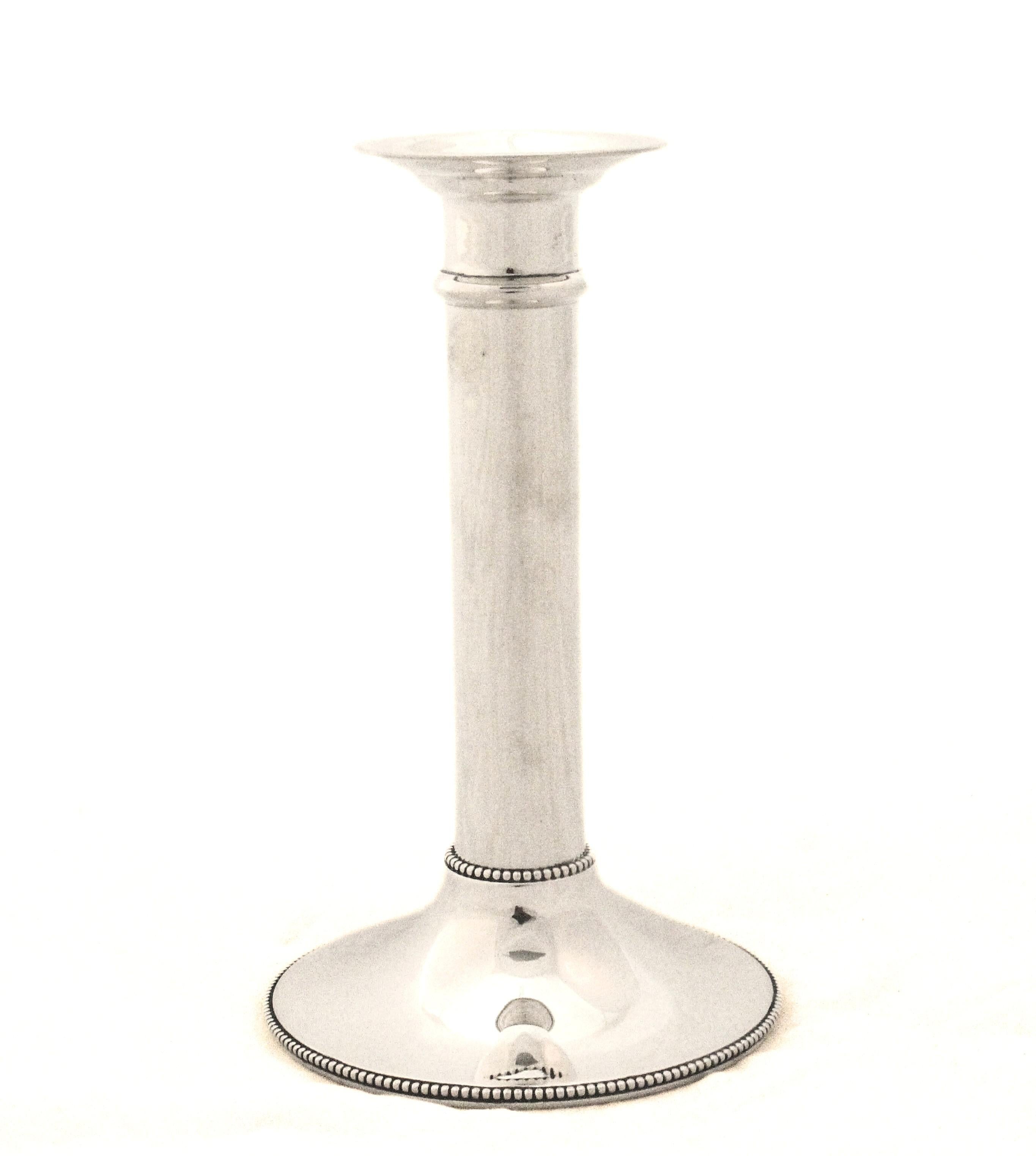 Un design elegante e sobrio in pregiato argento sterling, caratterizzato da basi circolari con un delicato bordo di perline lungo il bordo e ulteriori perline che accentuano la giunzione tra la base e l'asta. I fusti alti e affusolati si ergono con