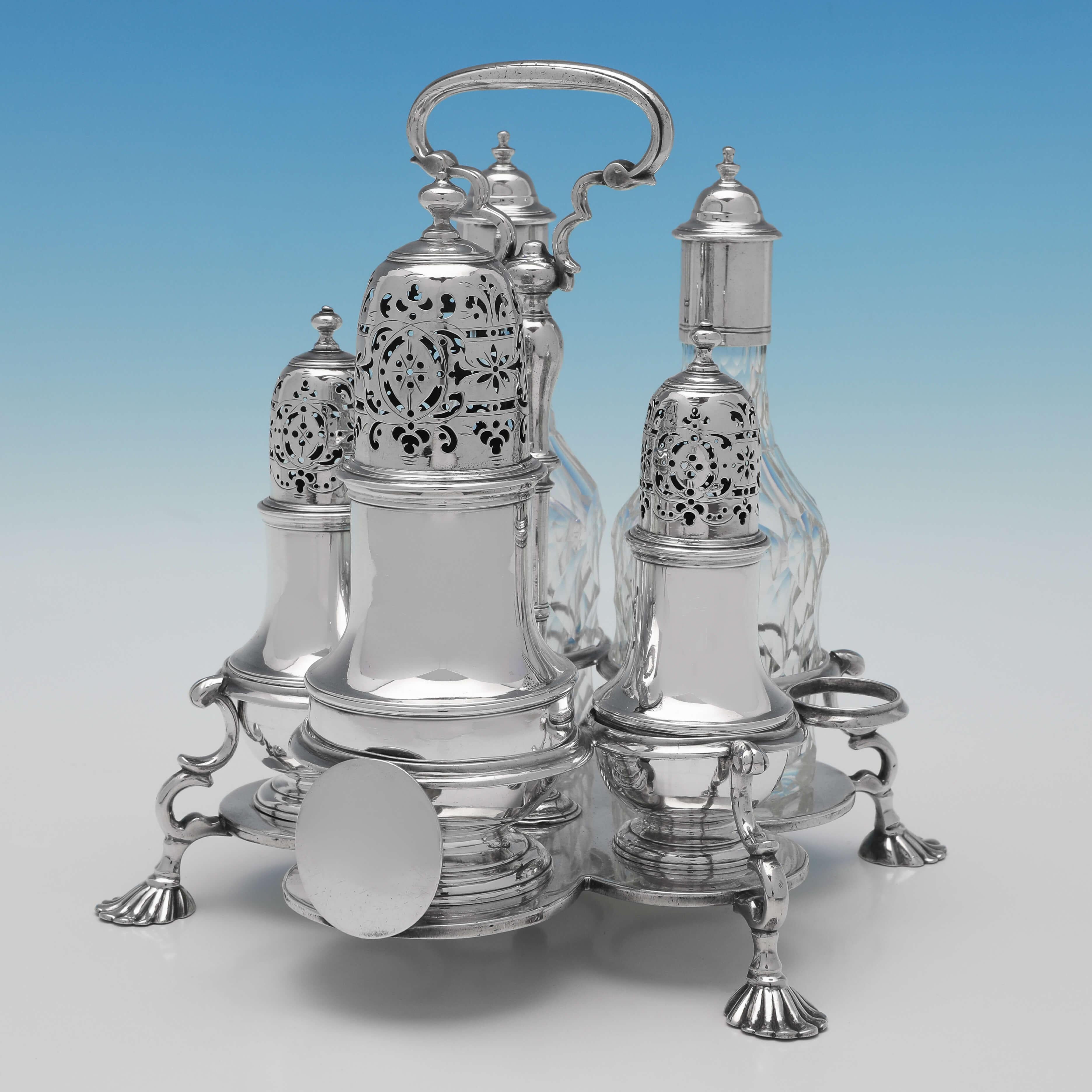 Hallmarked in London in 1726 by Thomas Bamford I, this magnificent, George I, Antique Sterling Silver Warwick Cruet, comprises two oil bottles, two pepper pots and a sugar caster, all fitted to a scroll detailed frame which stands on four cast shell