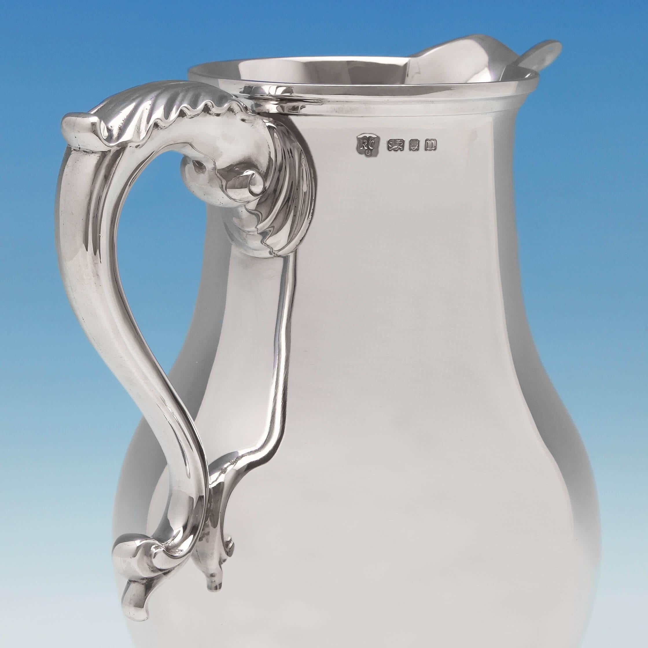 Hallmarked in London in 1928 by Richard Comyns, this fantastic sterling silver water jug is in the style of a Classic George III Beer jug, with a baluster body, acanthus topped handle, beak spout and pedestal base. 

The jug measures 9.5