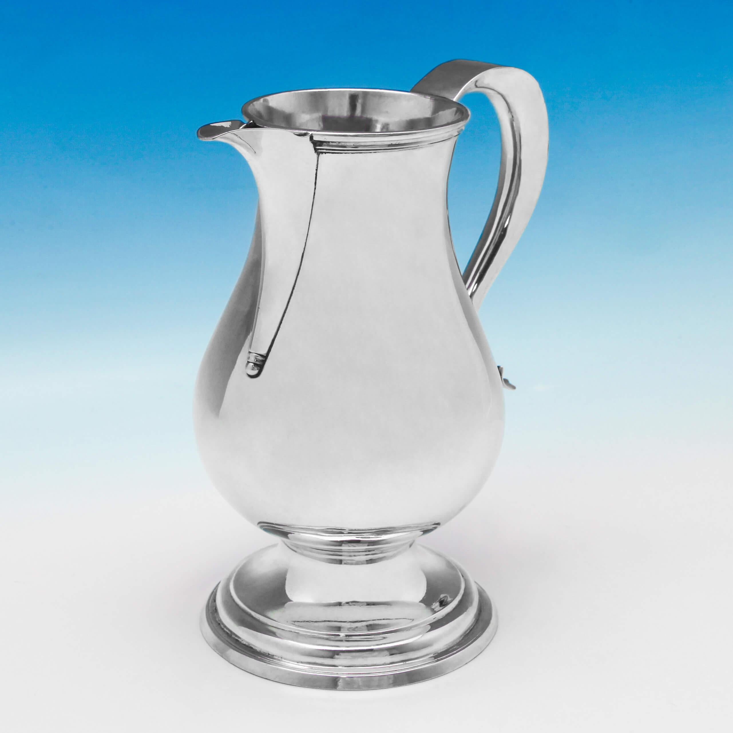 Hallmarked in London in 1755 by John Robinson II, this fine quality, George II, antique, sterling silver water jug, has a baluster shape, a “sparrow beak” spout, reed borders and a scroll handle. The water jug measures 8