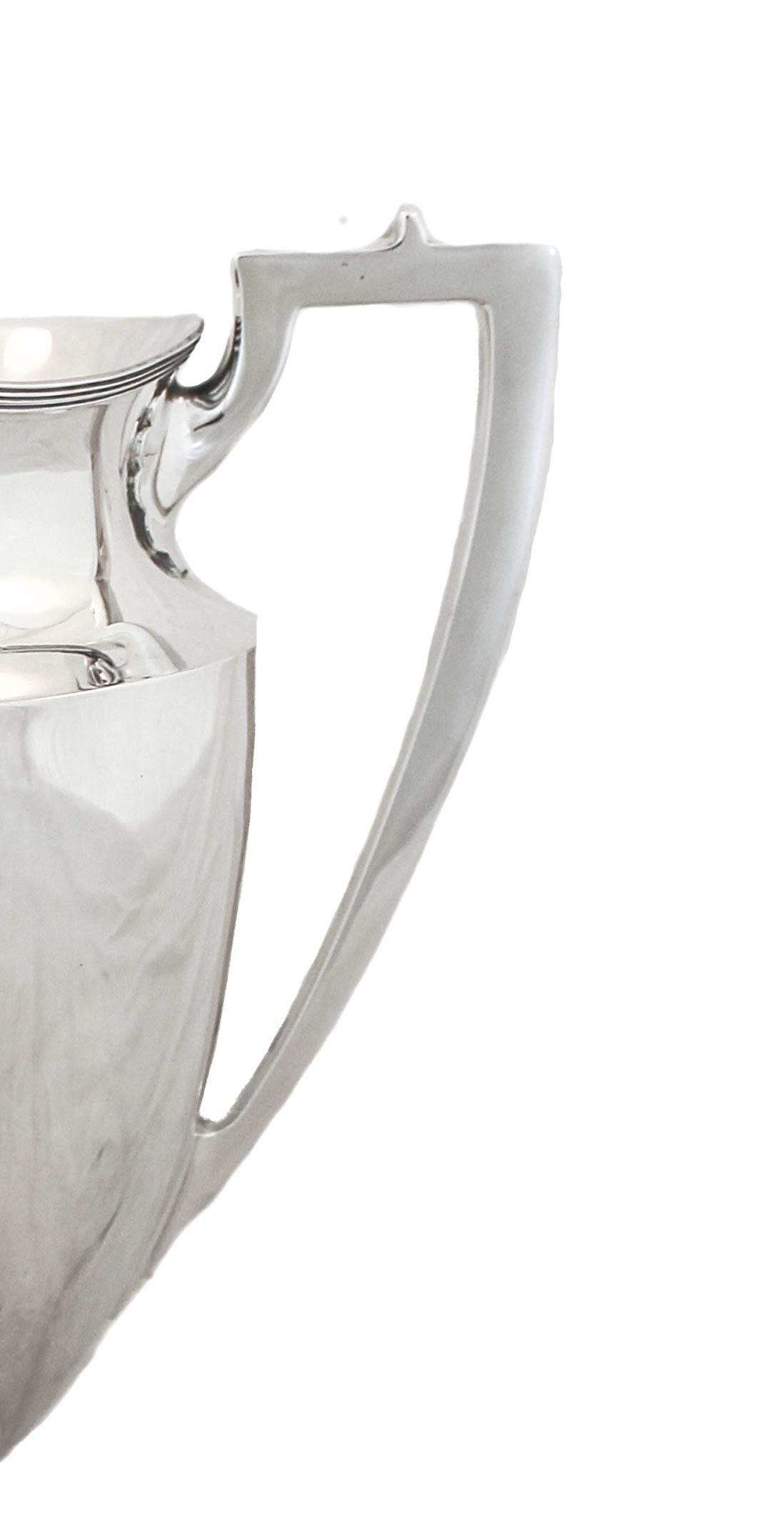 We are happy to offer you this sterling silver water pitcher by Black Starr & Frost. Designed in the Federal style, it is understated and simple with no etchings or decoration — keeping with the minimalist look. Notice the square shaped handle and