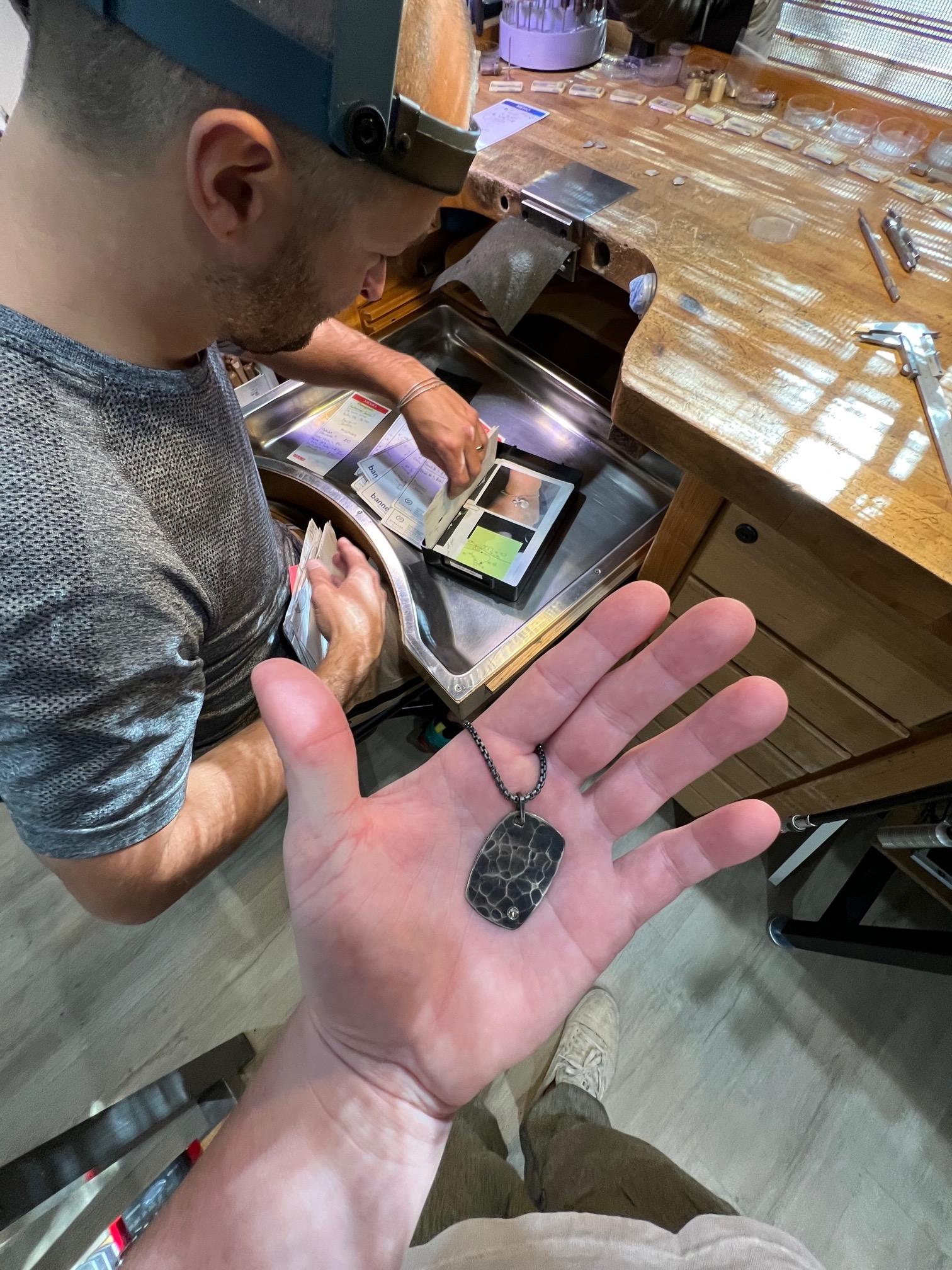 Hand crafted and forged dog tag by Jared Porter Studio.  This dog tag is sterling silver and has a dark patina (oxidized)  finish to the pendant and chain.  The surface has a hand pounded finish to that mimics water ripple's.  The bottom of  the