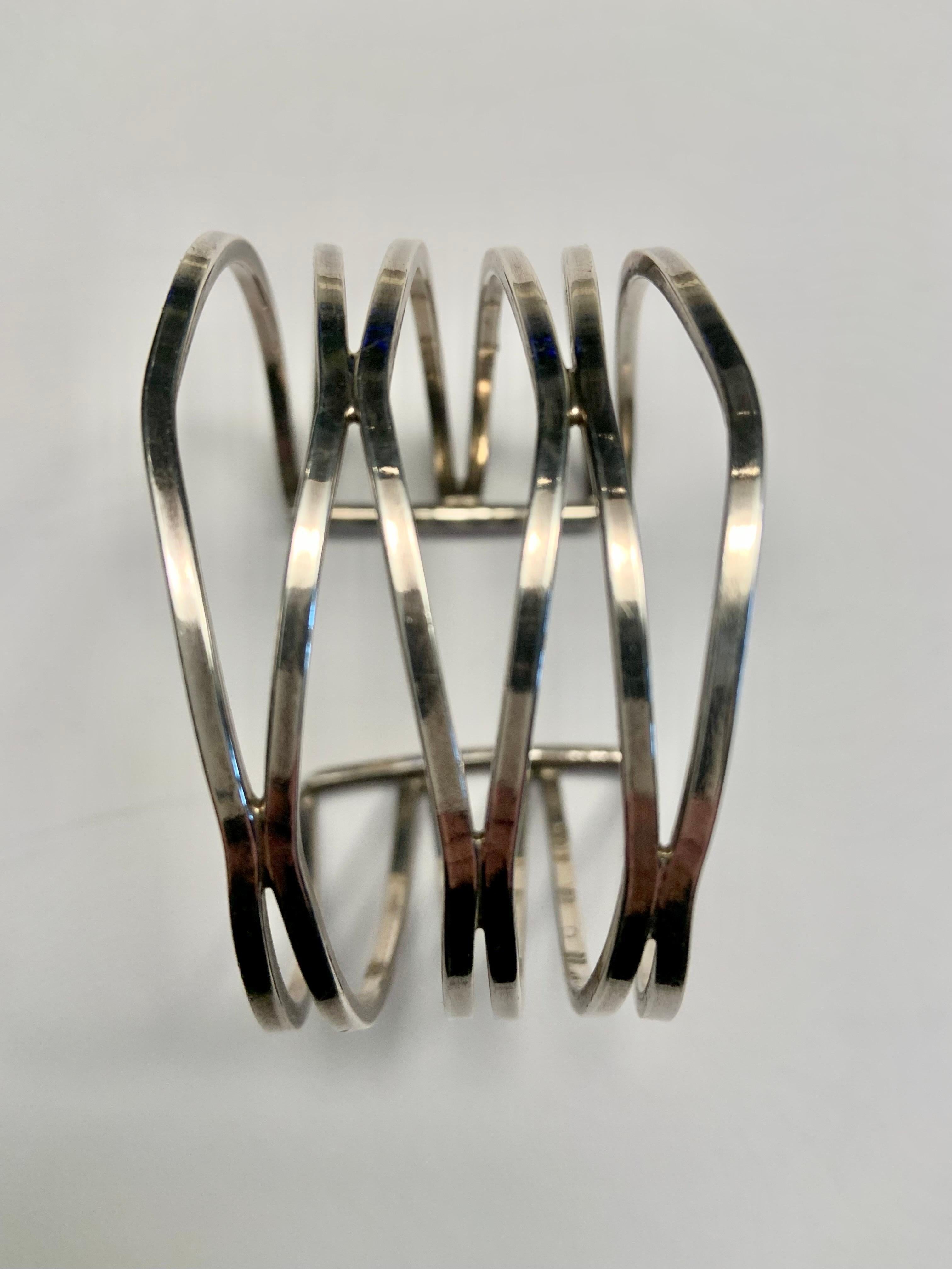 This is a very chic sterling silver cuff, composed of three pairs of silver bands undulating from one side of the wrist to another, like a wave.  It is marked 925 on the inside but it is not signed. The bracelet is in excellent