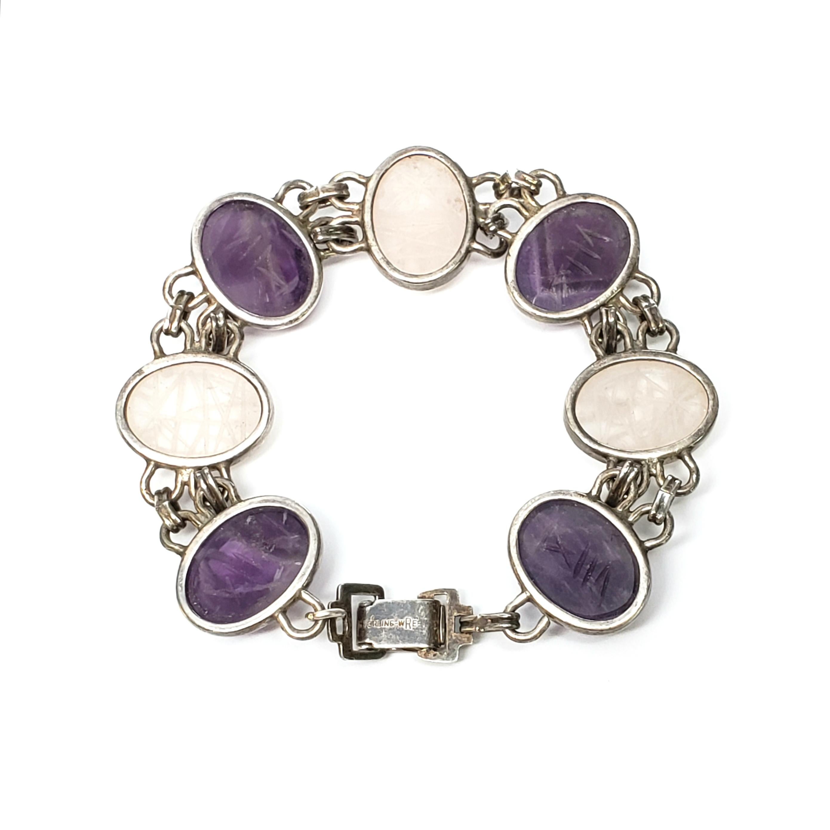 Vintage sterling silver scarab bracelet by designer WE Richards.

Made by WE Richards of Attleboro, MA, the bracelet features carved glass oval purple and clear stone bezel set links.

Measures 7