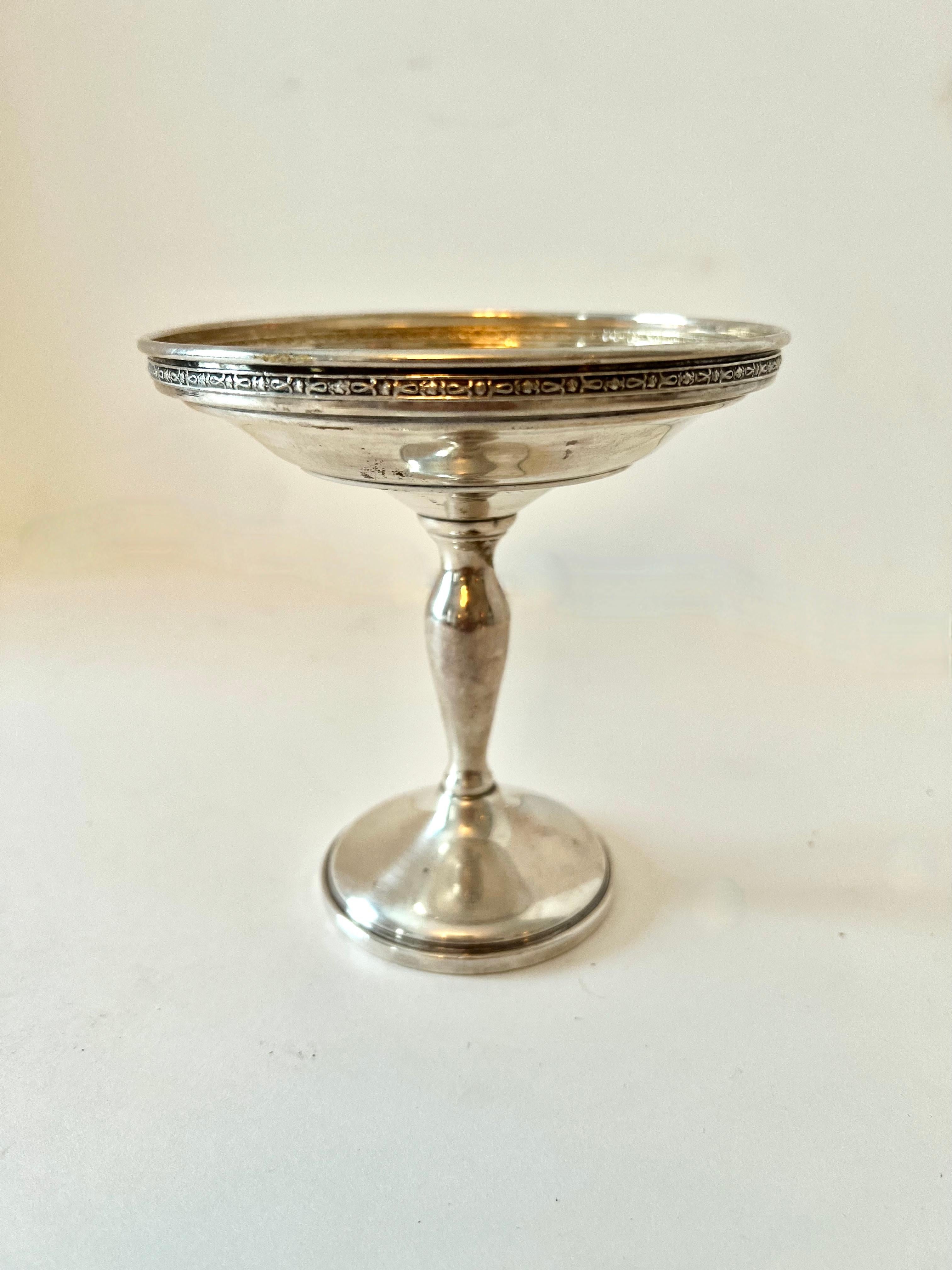 A lovely Sterling Silver compote with a simple and sophisticated edging.  The piece is a compliment to any cocktail table or bar... serving nuts to candies or for display of a floating flower.  please see our images for ideas. 

A wonderful hostess