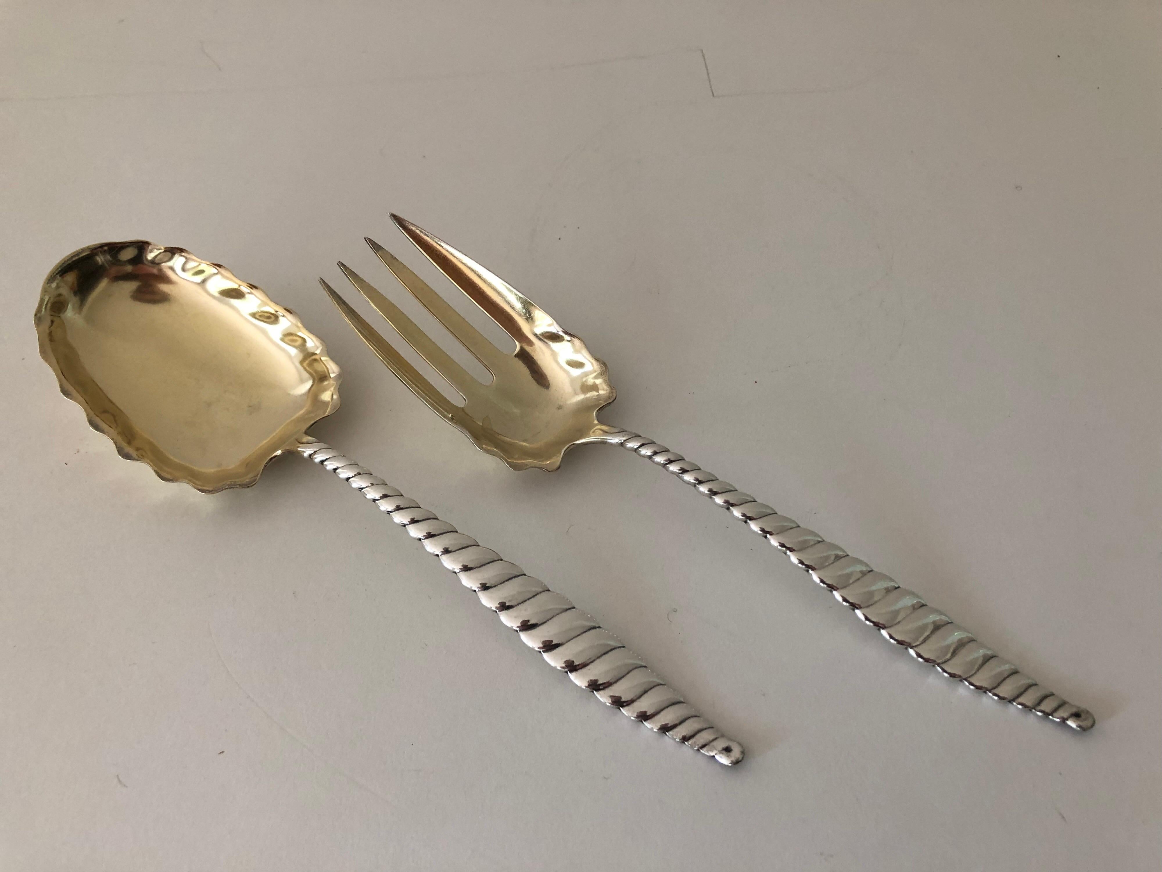 An antique set of sterling silver salad servers by Whiting Manufacturing Company, late 1800s. The set includes a serving spoon and serving fork. Oval twist pattern with gold washed tines.

  