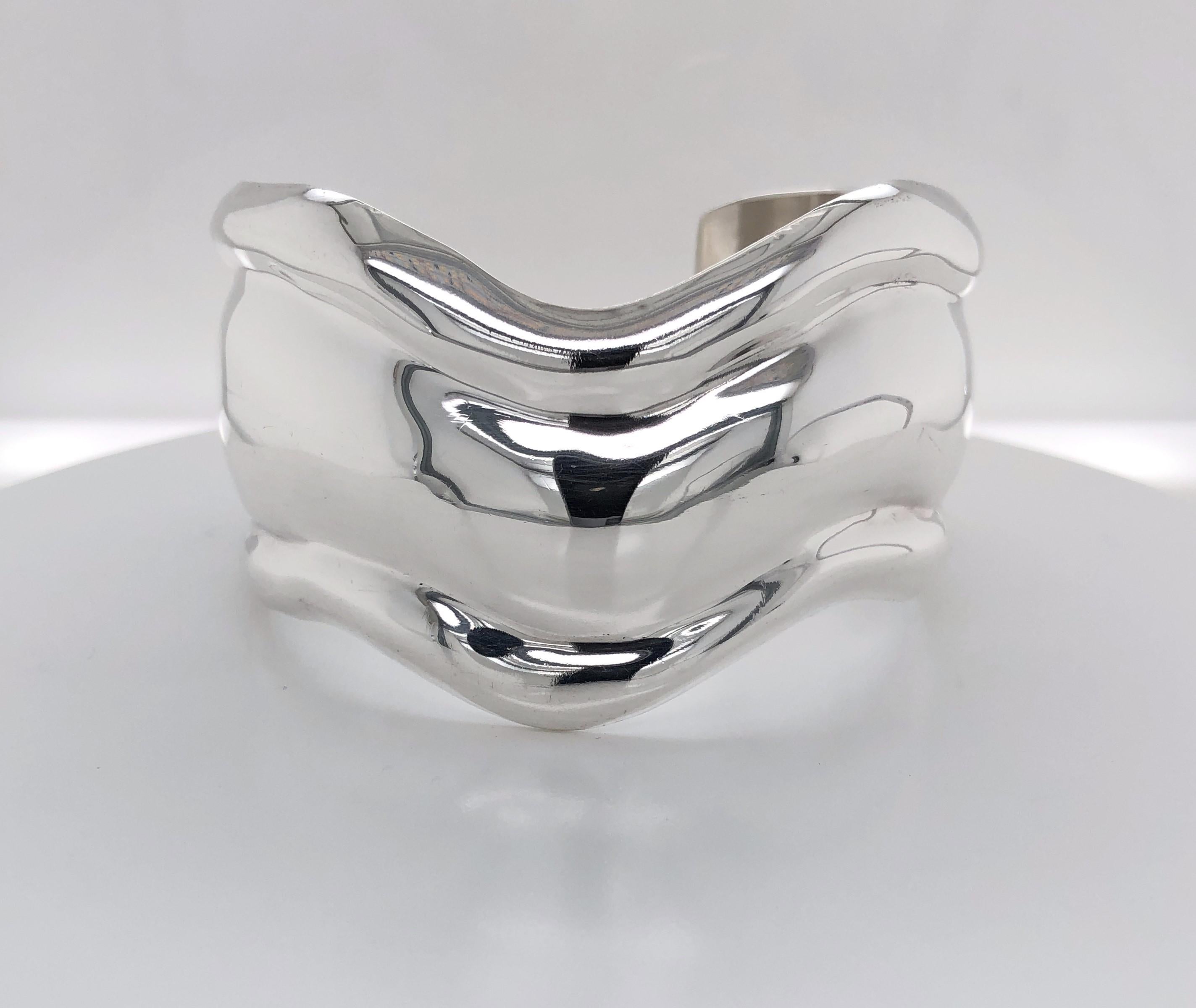 Beautifully sculptured and contours the wrist, this substantial wide bone cuff bracelet creates a stylish modern statement. Measures 1-1/4 inches wide and 6-1/2 inch around with an opening of 1-1/8 inches and is nicely polished. Stamped and signed,