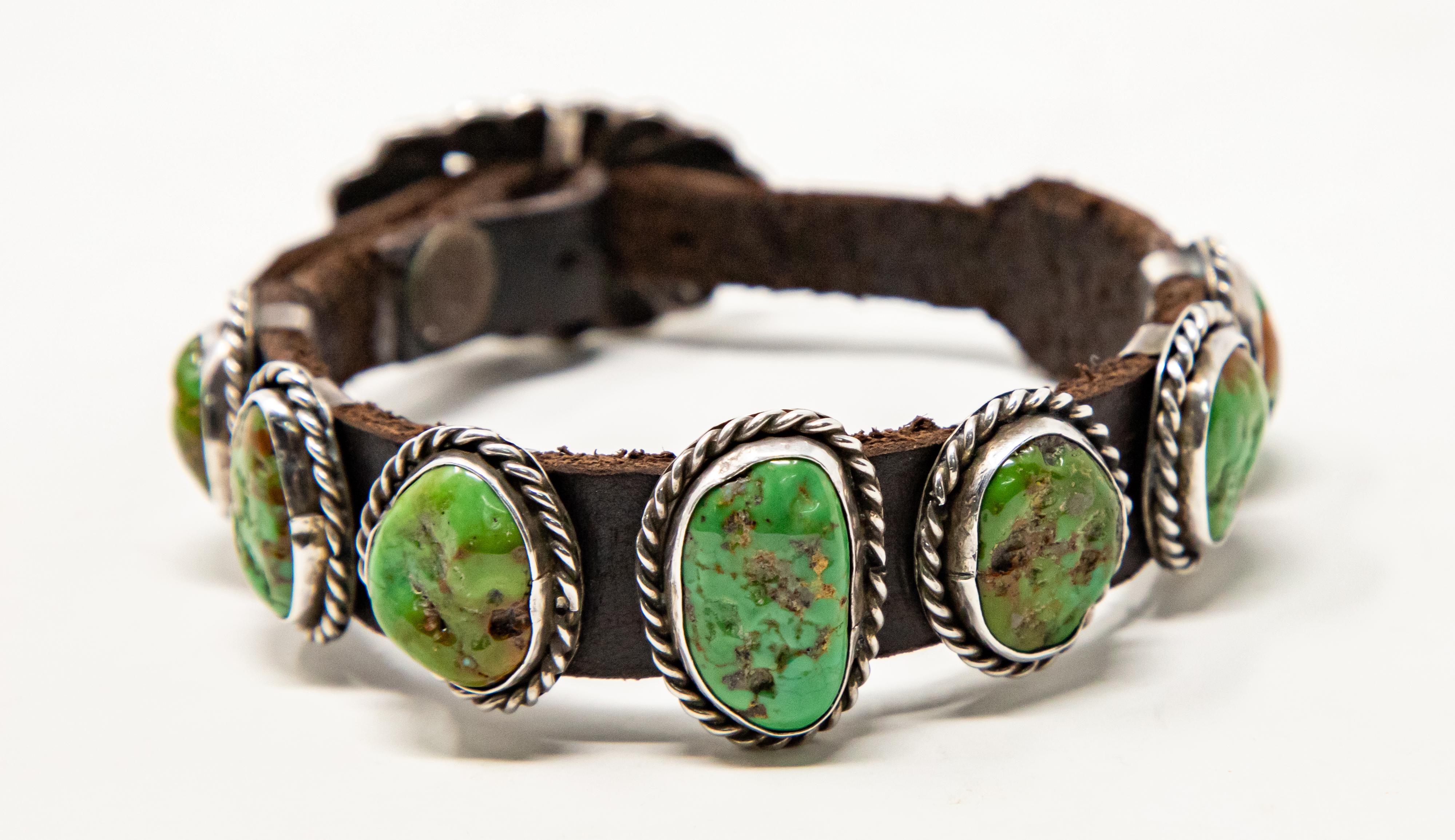 This stunning bracelet is up for your consideration. Having seven turquoise pieces set in sterling silver and banded to leather. Has a buckle that is sunburst with rounded tips. Hallmarked Sterling, DM on the back of the center stone.