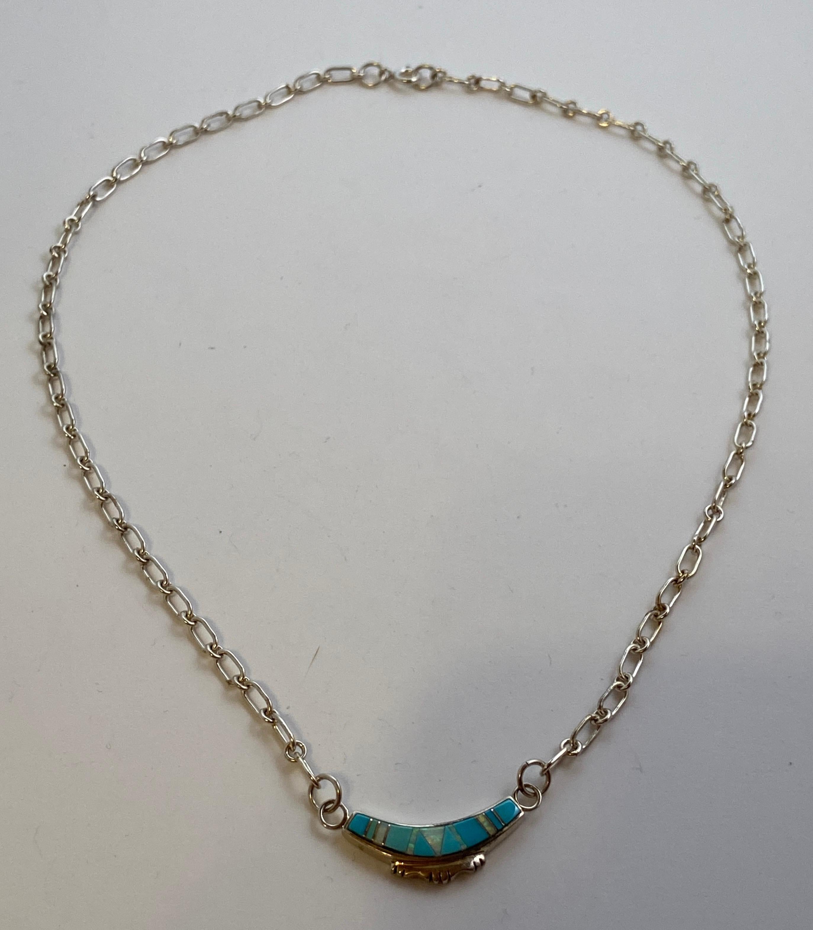 Sterling Silver chain-link necklace is highlighted with a sterling silver pendant accented with opal and turquoise and silver. The pendant measures 1 1/8 inches by 2/8 of a inch. The total length of the necklace measures 18 inches. Made in US.