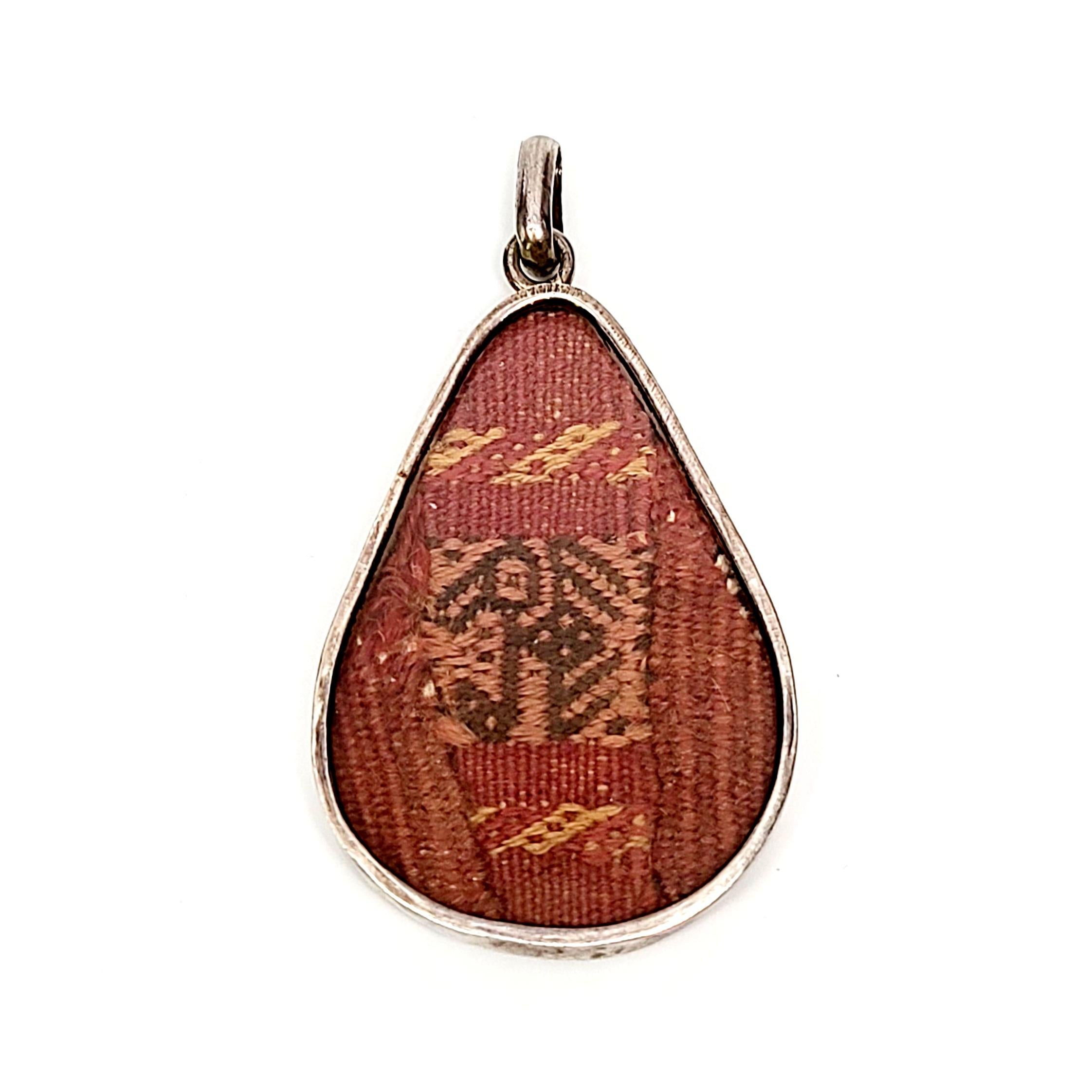 Vintage sterling silver and woven textile pendant.

A beautifully woven Tribal textile is encased in a sterling silver framed teardrop shaped pendant.

Measures approx 2 1/2