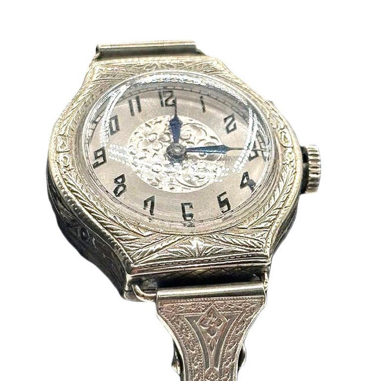 Beautiful 16-jewel mechanical manual movement by Elaine with an early Art Deco sterling silver watch showcases graceful hand-etched floral and vine motifs. The sterling case and 12-hour dial feature elegant detailing, complemented by a timeless