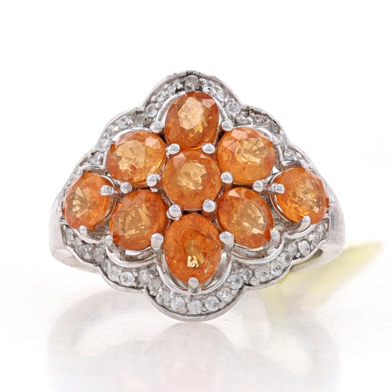 Size: 8

Metal Content: Sterling Silver

Stone Information
Natural Spessartite Garnets
Carat(s): 3.50ctw
Cut: Round & Oval
Color: Orange

Natural White Sapphires
Carat(s): .45ctw
Cut: Round

Total Carats: 3.95ctw

Style: Cluster with