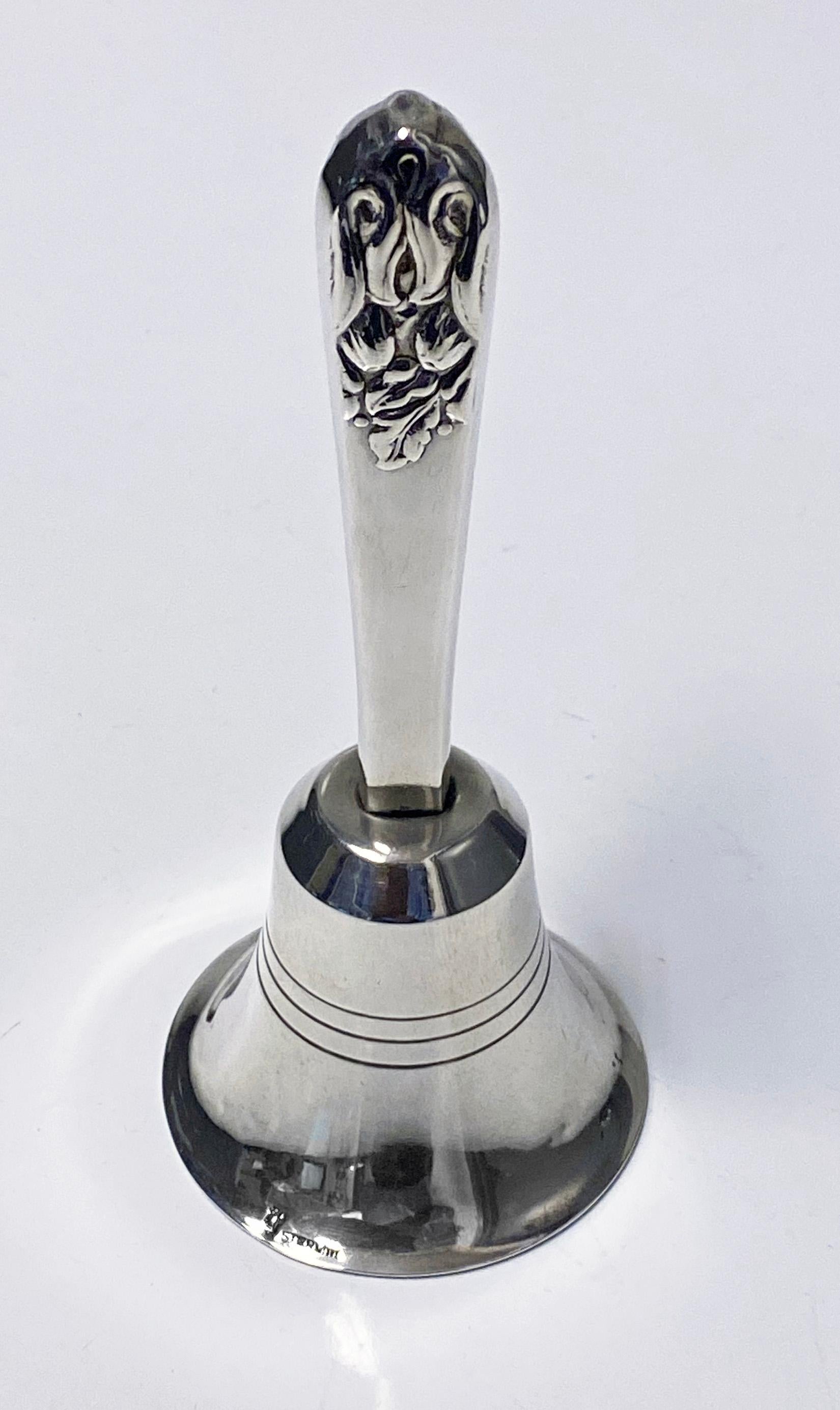 Sterling Table Hand Bell Carl Poul Petersen, Montreal C.1930. The Bell of a Danish Jensen style on flared dome base, the handle of blossom style. Stamped Sterling with Petersen marks. Height: 5 inches. Weight: 49.4 gm.