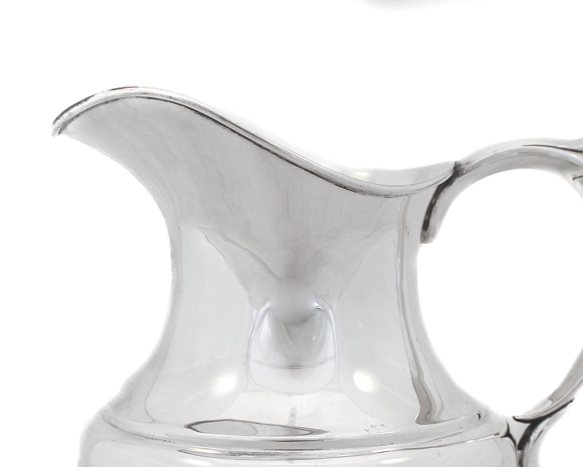 We are happy to offer you this sterling silver water pitcher by Reed and Barton in “The Pilgrim” pattern from the early 1940’s. Sterling silver hollowware that was manufactured during the war was very understated and simple; a reflection of the time