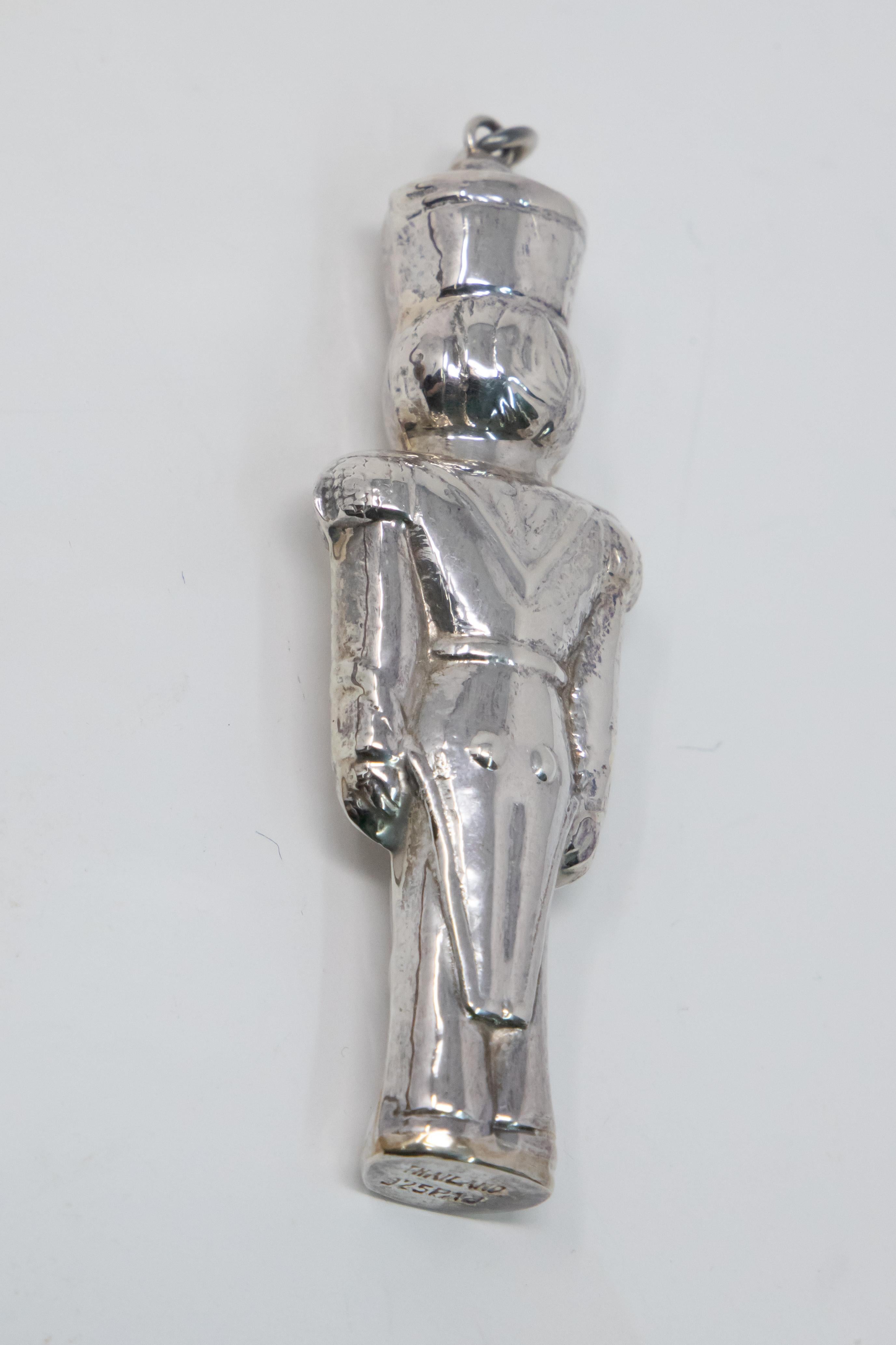 Offering the beautiful toy soldier sterling ornament. He is done in a three dimensional way. Simple lines and clean he is depicted standing at attention with arms to his sides. The bottom is marked Thailand, 925, PAJ.
