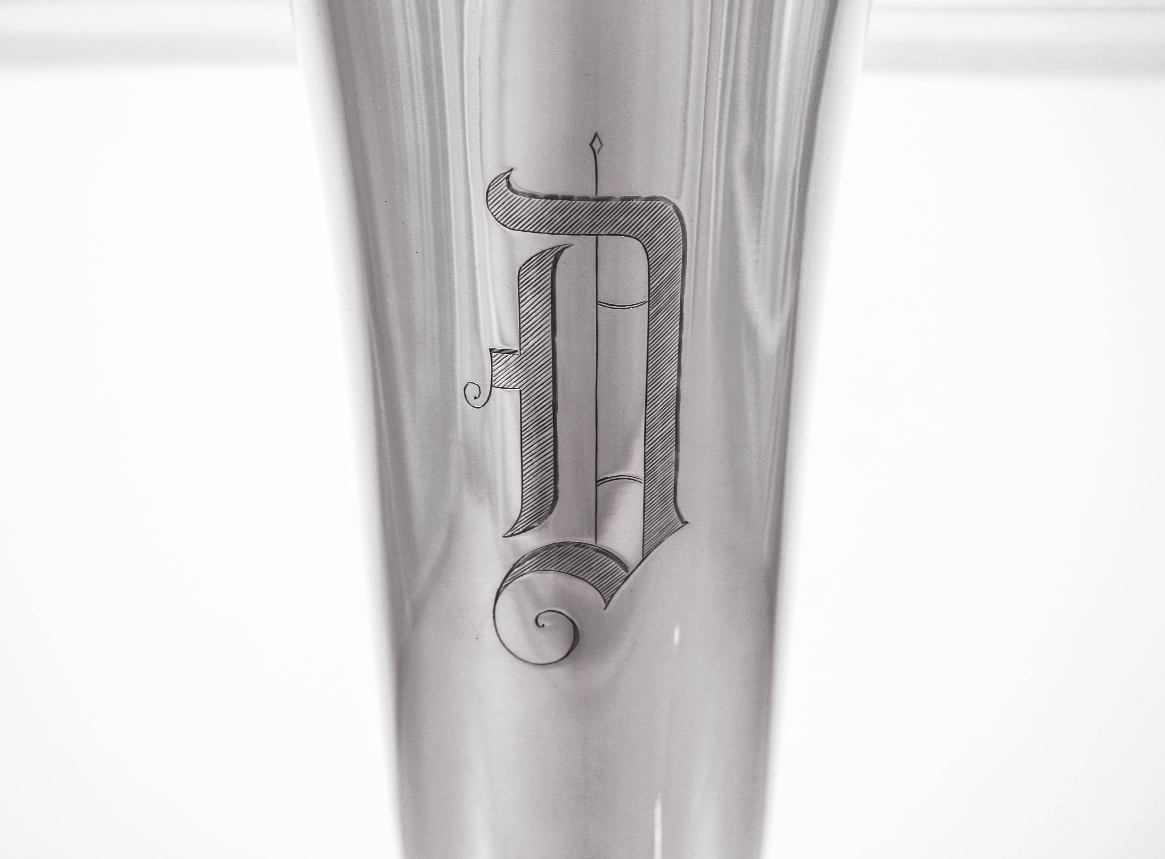 We proudly offer this sterling silver vase by the Shreve Sterling Company of San Francisco, California. It has a fluted rim and an Uber-clean minimalist look. There’s a hand engraved D in the Old English font. It has a curvy shape that’s feminine