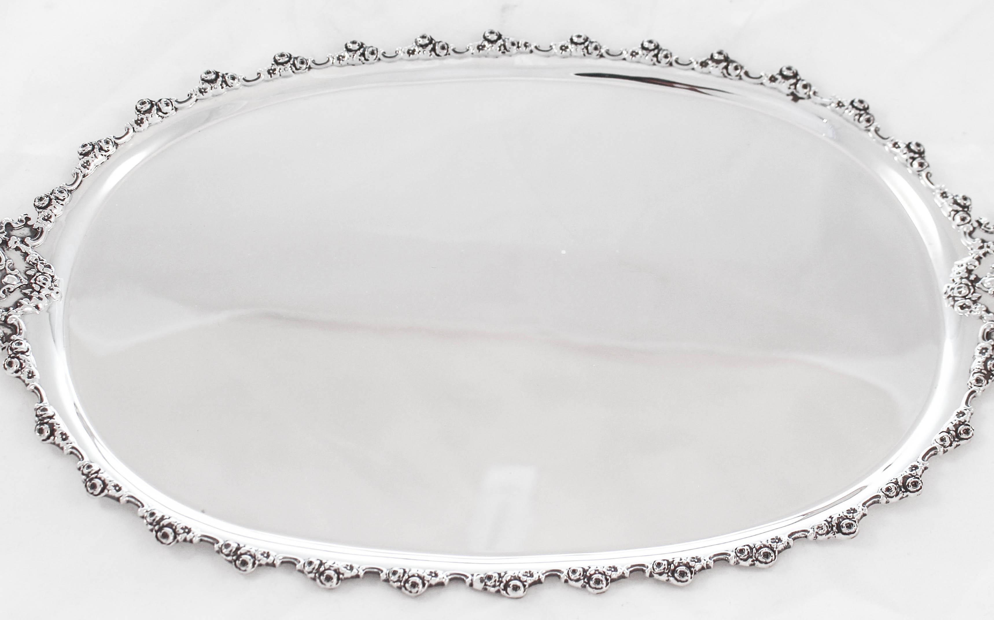 We are thrilled to offer this sterling silver vanity tray by the Frank Smith Silver Company of Massachusetts. It has a floral motif going around the scary edge. On each end the tray extends out to form handles. The center is completely flat; ideal