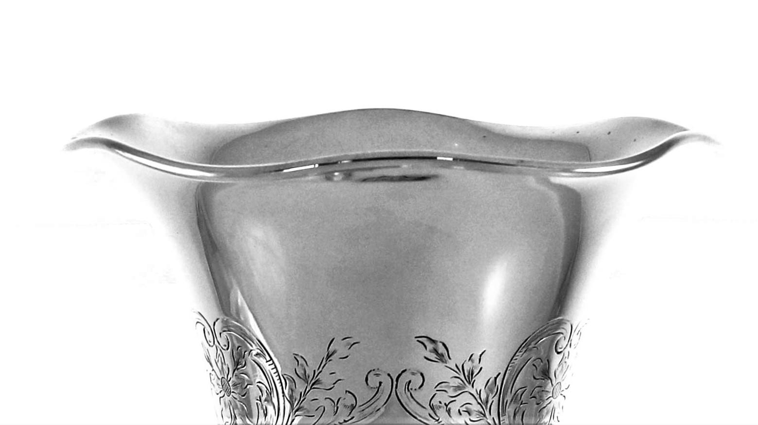 Diese schöne Vase aus Sterlingsilber hat einen gewellten Rand und eine schöne Silhouette. Die Form ist kurvenreich und weich. Um den Sockel herum und auf dem gesamten Korpus finden sich geätzte Blumen, Blätter und Wirbelmuster. Die Dekoration ist