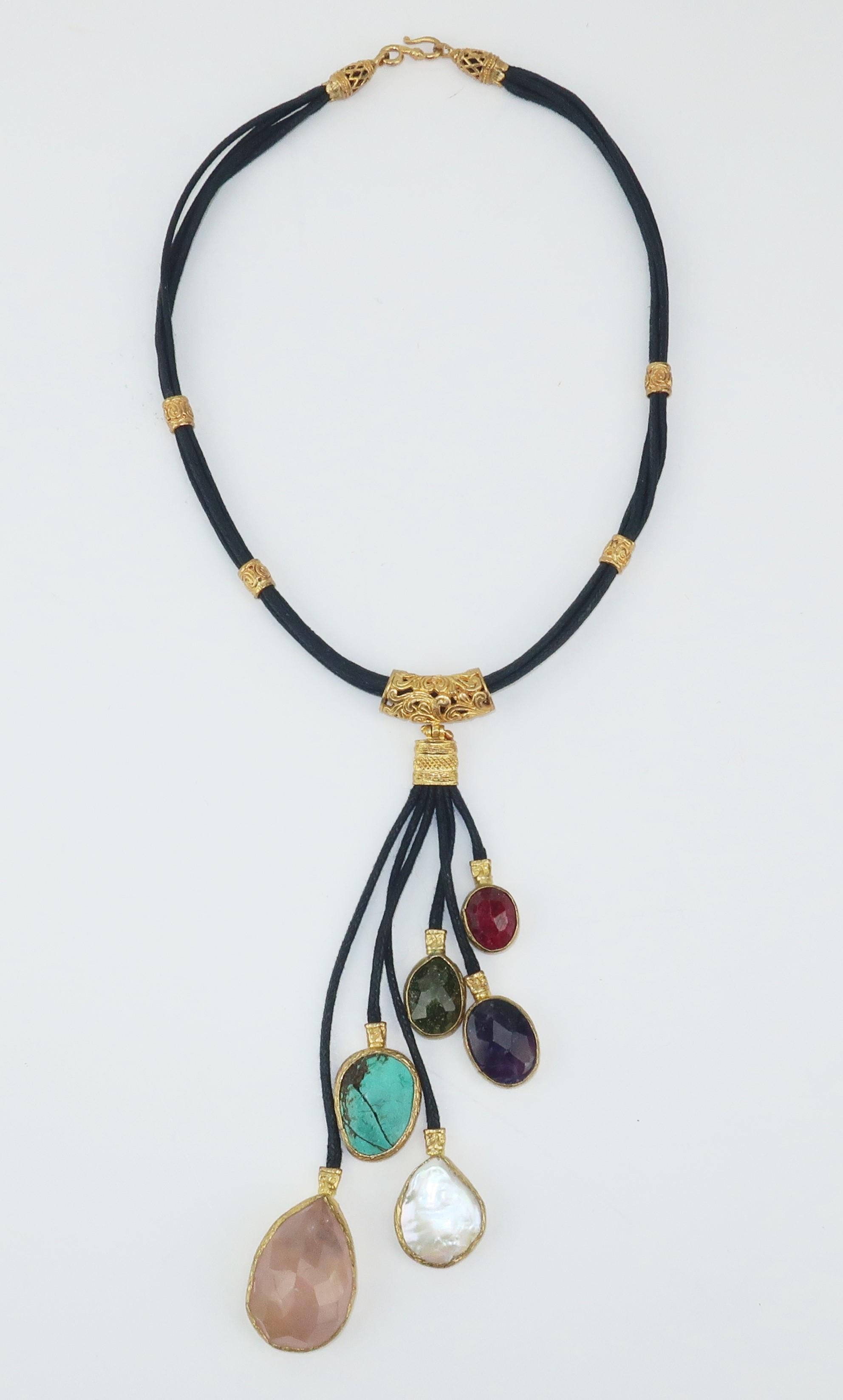 An exotic necklace in braided leather cords laced with filigree sterling fittings with a gold wash all suspending semi precious drops at staggered lengths including rose quartz, mother-of-pearl, turquoise, amethyst and garnet.  Easy byzantine style