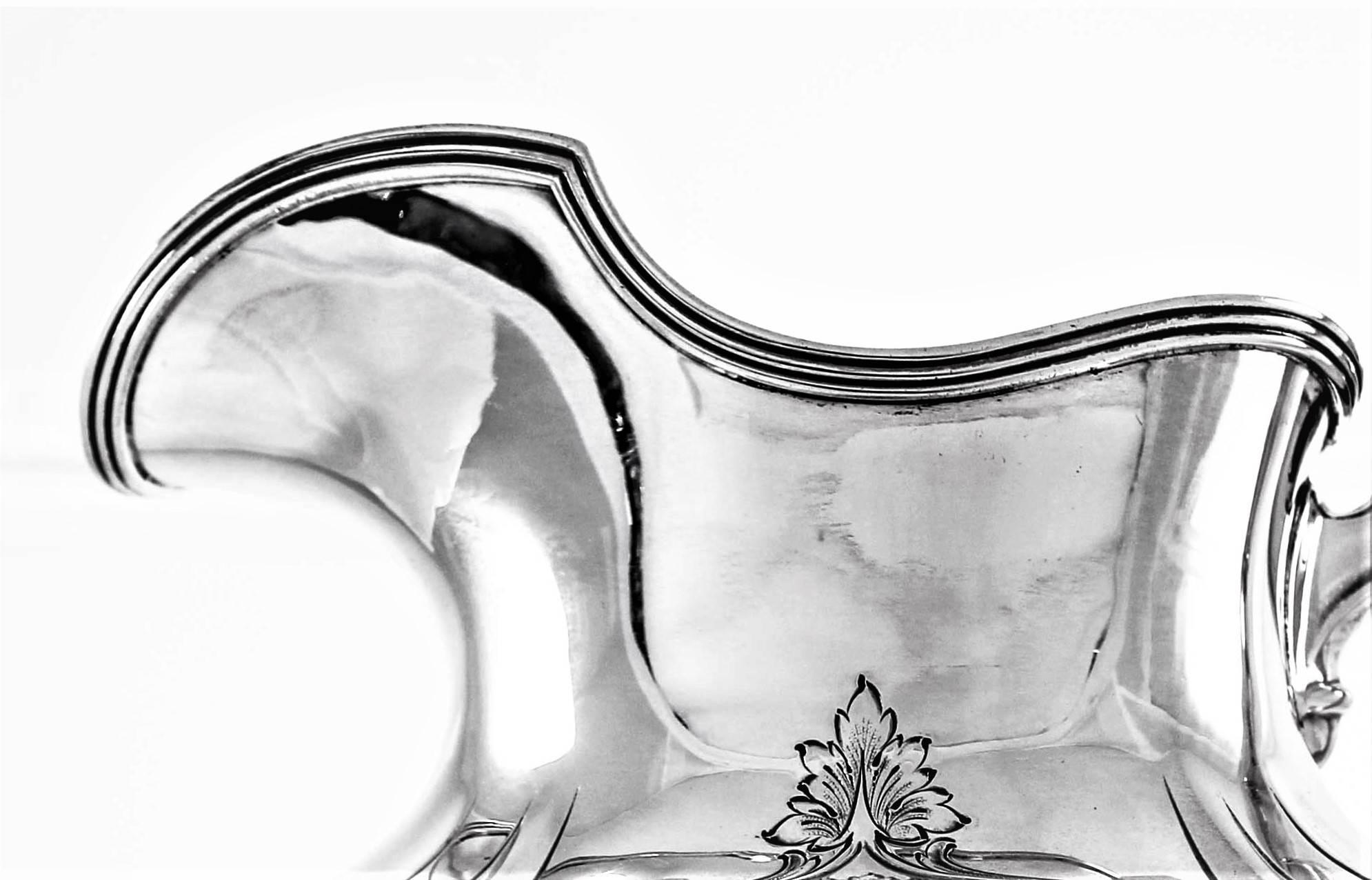 Designed in the federalist style, it also has a beautiful etching pattern around the centre. Leaves, flowers and garlands along the scalloped body. Its shape is oval and the spout has a narrow opening for easy pouring. Along the top, there is