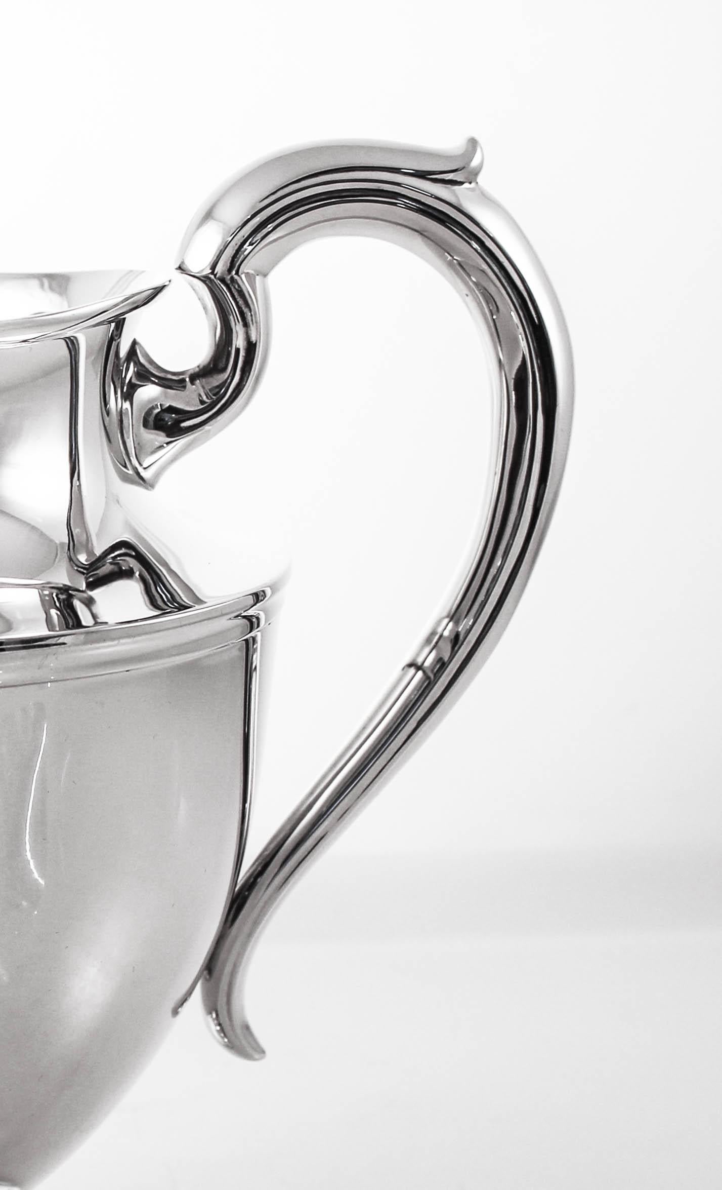 Proudly offer this sterling silver water pitcher by La Pierre Co of New York. A sleek and un-ornate piece, it will match any flatware, dishes and stemware. It has a universal look that blends beautifully with either a fussy or simple decor.