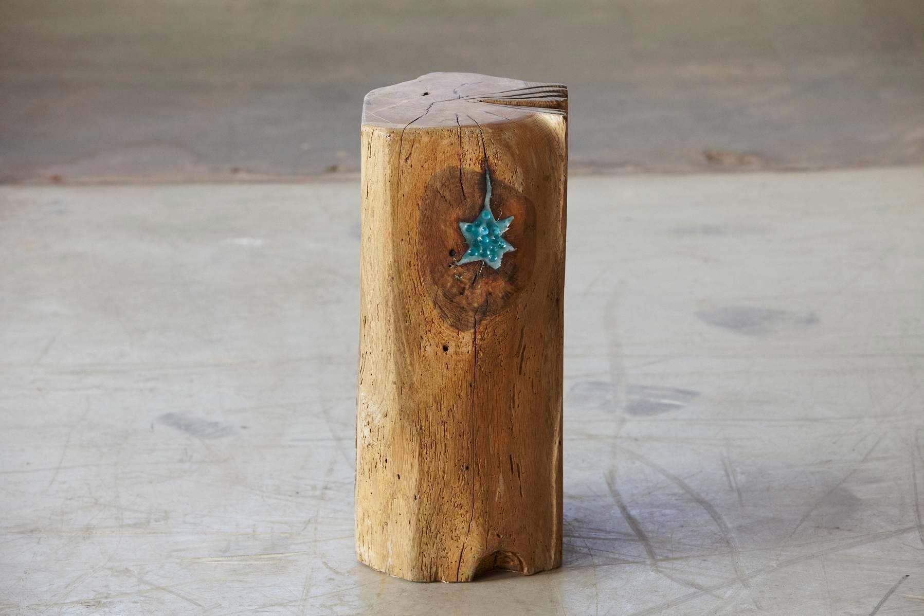 Stern - Star. 
A wooden, hand-carved one of a kind stool made from a solid piece of oak by German artist Hanni Dietrich. 
All wood used by the artist is from salvaged oak beams or naturally fallen trees.
 