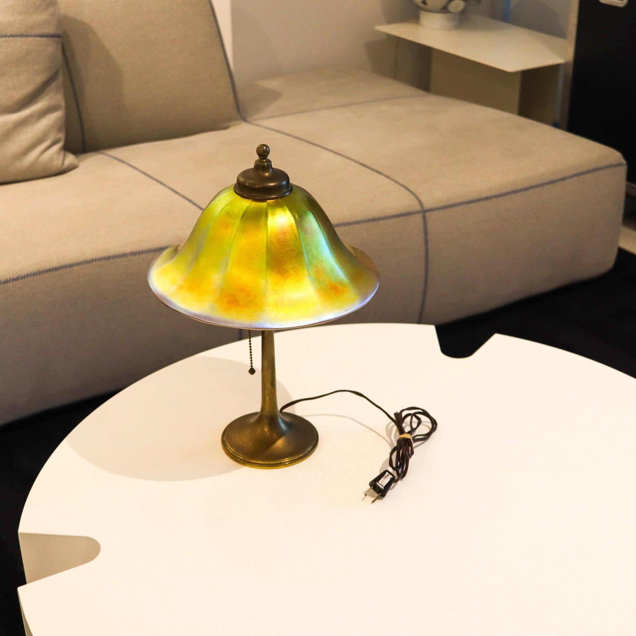 Art nouveau table lamp by Roycroft and Steuben.

This is a fabulous table-desk lamp, created in New York United States by the Roycroft Lamp Company  and the Steuben Company. The lamp components is an authentic Aurene Art Glass Bell Shade with golden