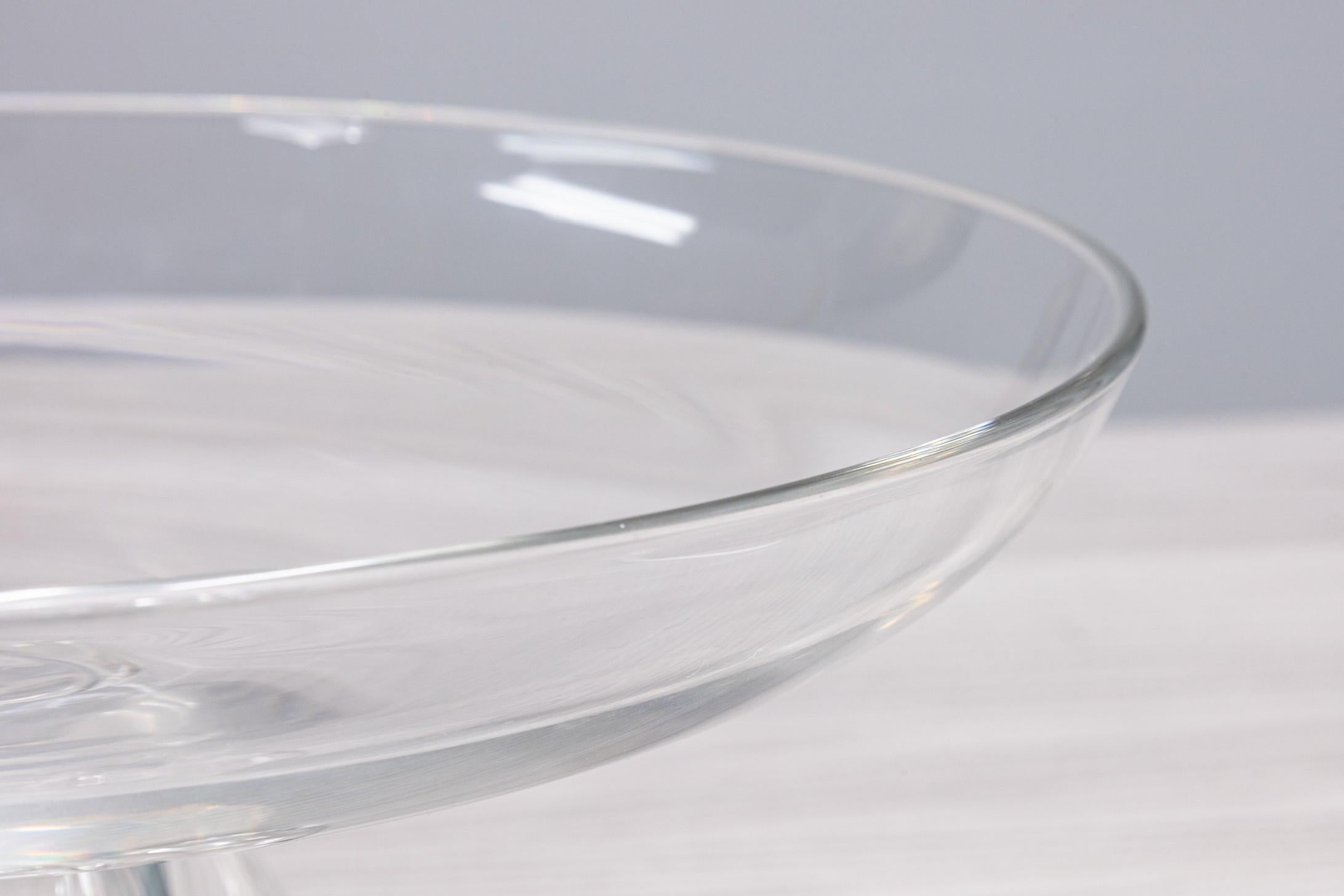 An incredible centerpiece bowl from Steuben glass in 1960. This piece features a wide shallow bowl with a heavy base featuring four teardrops falling down the pedestal. This piece is signed on the bottom. It measures 5.5 in tall, and has a 13.25 in