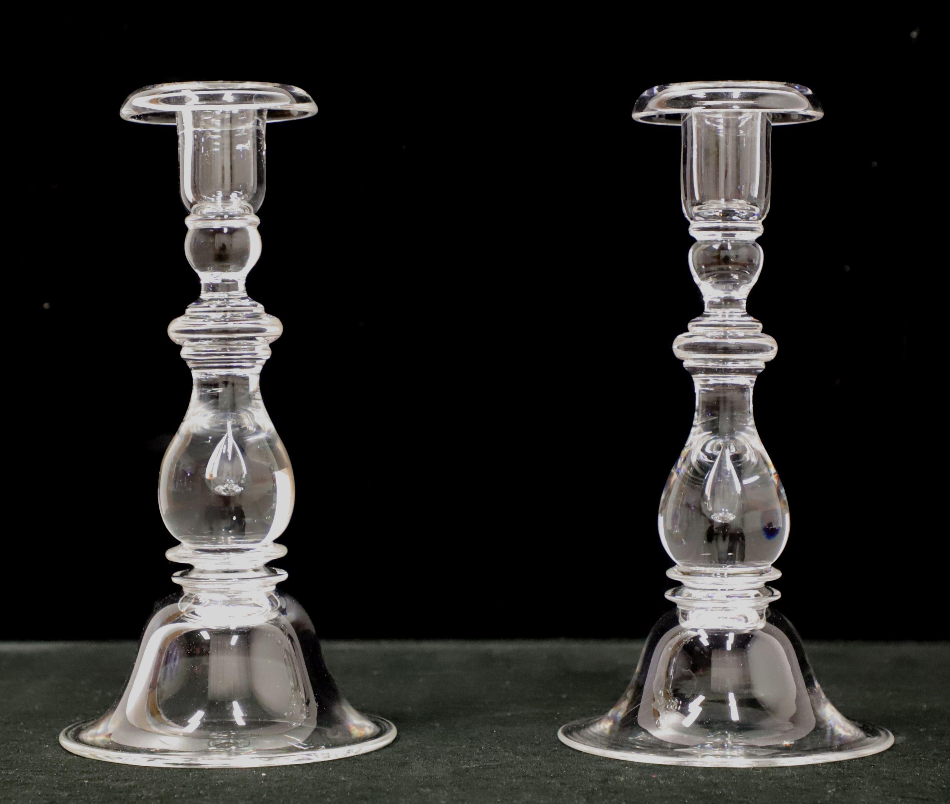 A pair of sparkling hand blown clear glass candlesticks from Steuben Glass. Each are a teardrop shape, single light and nine inches in height. Each are signed on bottom 