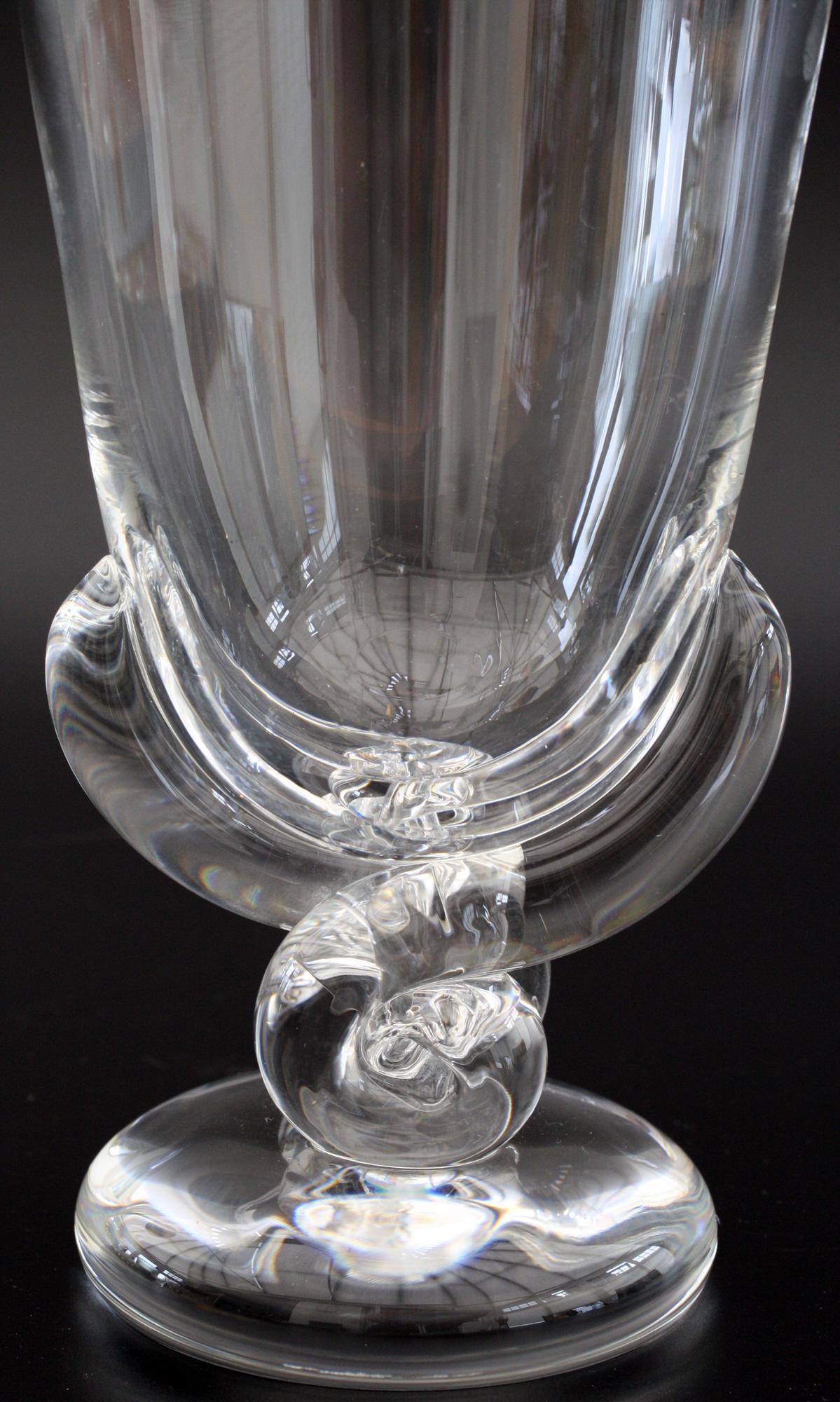 A stunning Art Deco Steuben art glass stylized flower shaped vase designed by George Thompson in 1942. This beautifully designed lead crystal vase stands on a heavy rounded foot with a coiled and stylized leaf shaped support and tall open flower