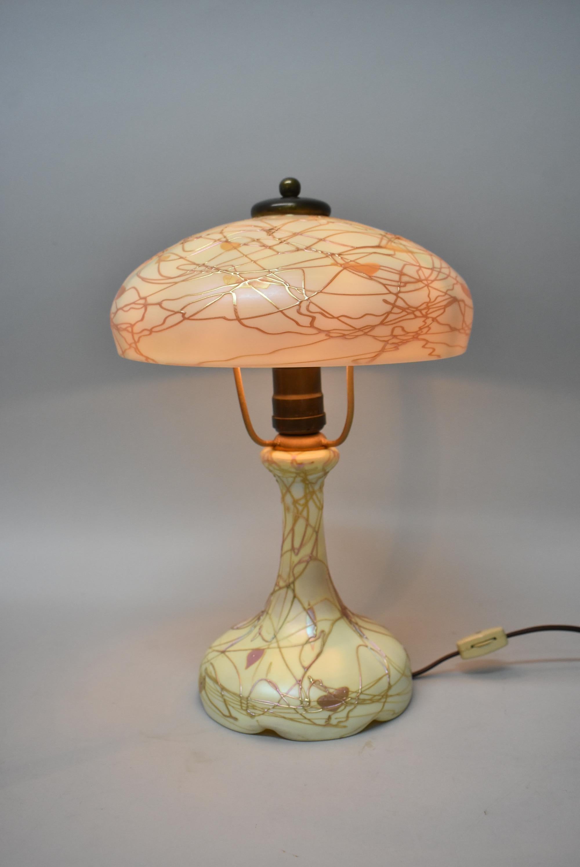 Esta impresionante lámpara de vidrio artístico de tocador Steuben está decorada con un corazón dorado y enredaderas. Esta lámpara tiene el casquillo Bryant original. La pantalla mide 20 cm de diámetro y la lámpara mide 25 cm de alto. Los detalles de