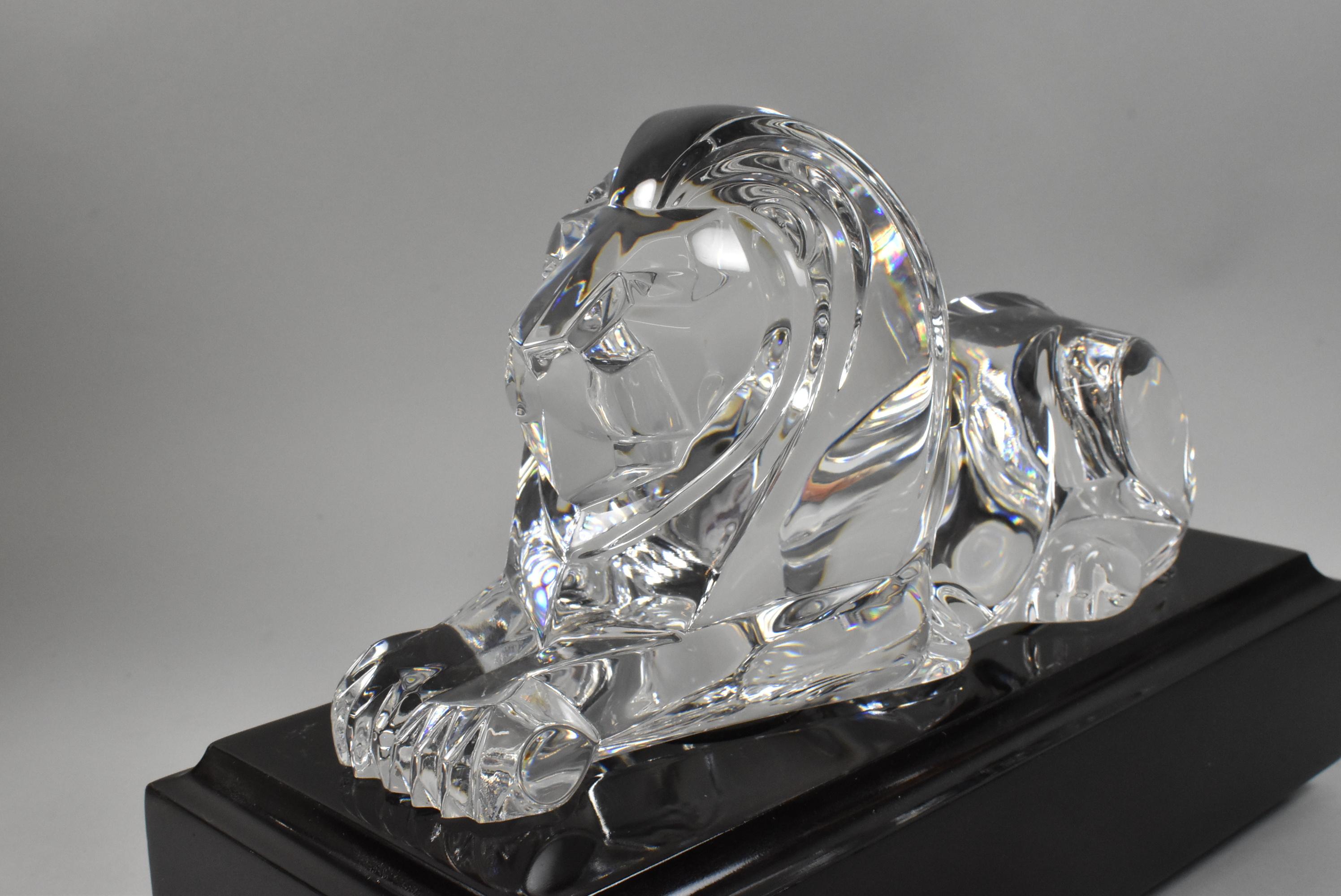 Steuben crystal laying lion with pedestal and original leather box. Designed by Lloyd Atkins circa 1986. No damage or scratches to crystal. Leather box has some wear.