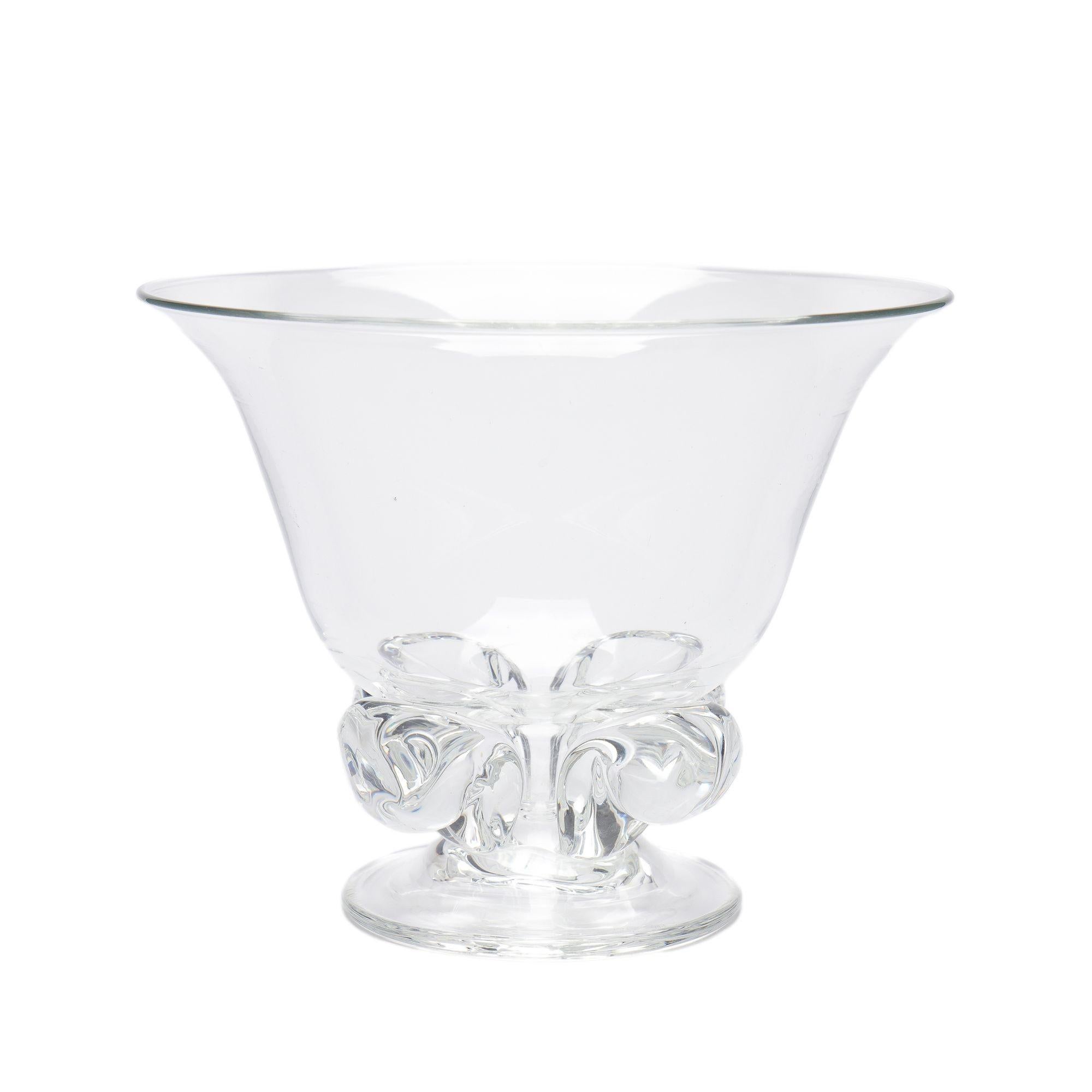 Si tratta di un vaso in vetro soffiato di forma rara, a campana, sostenuto da quattro volute pronunciate su un piede circolare. Questo vaso è stato disegnato da John Dreves e compare nel catalogo Steuben del 1948. Il vaso non è
