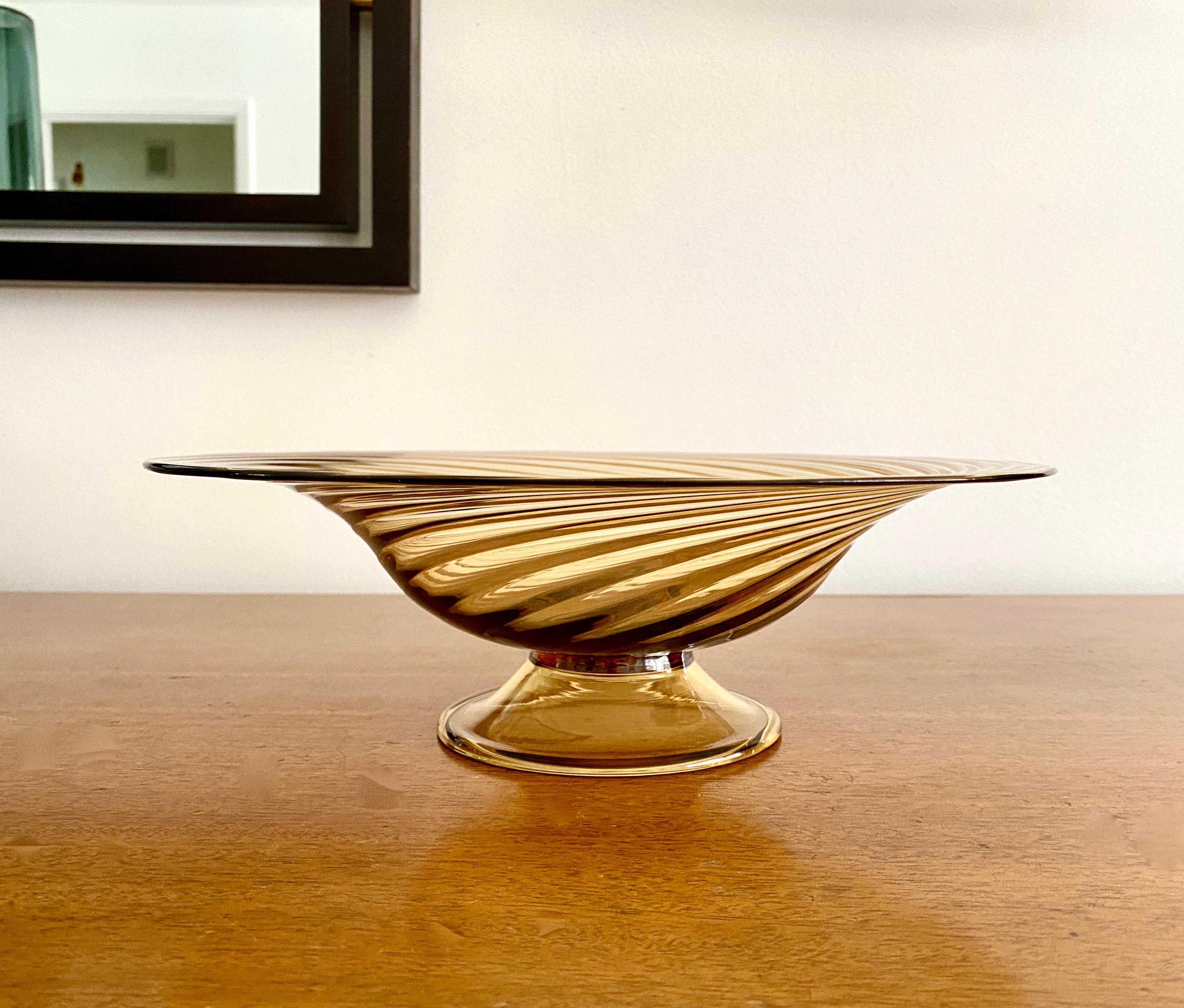 A transparent amber swirl lead glass compote or footed bowl, mold-blown and pattern molded. The compote is acid etched with the Steuben mark on the bottom. The vase was manufactured sometime during the 1920 to 1929 time period during Frederick