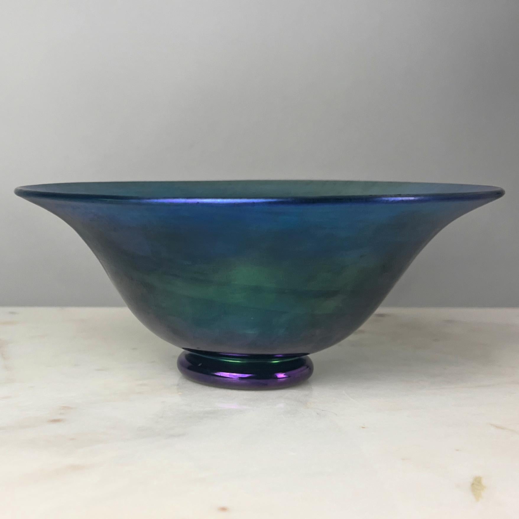 Questa splendida ciotola blu aurena di Steuben Glass Works è stata realizzata tra il 1903 e il 1932, un periodo caratterizzato dalla visione innovativa di Frederick Carder. La ciotola, forma #2851, mostra la squisita abilità artigianale tipica del