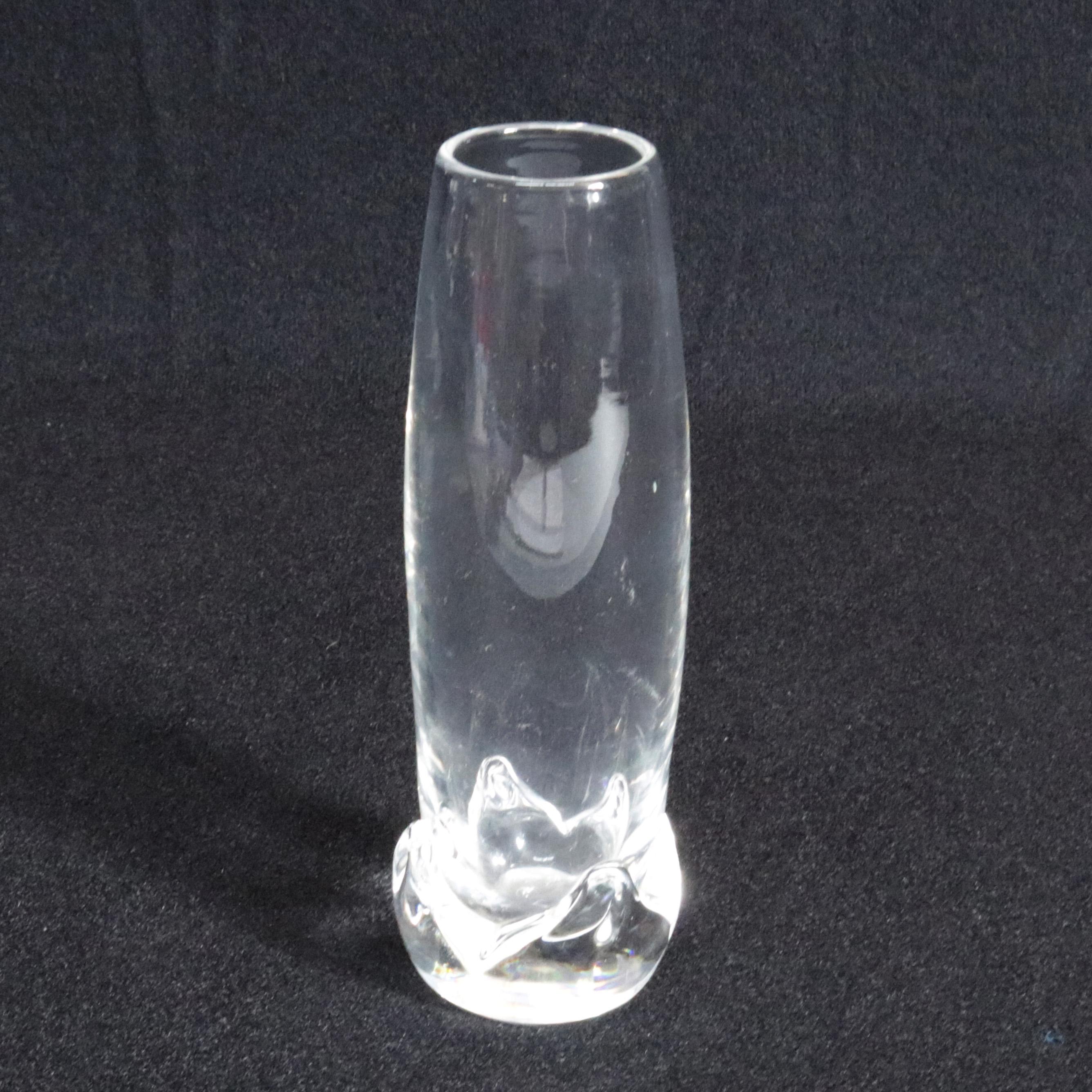 Mid-Century Modernist Steuben mouth blown bud vase features colorless art glass seated on floral form base designed for Corning Museum of Glass, New York, NY, signed on base, 20th century.


Measures: 6.75