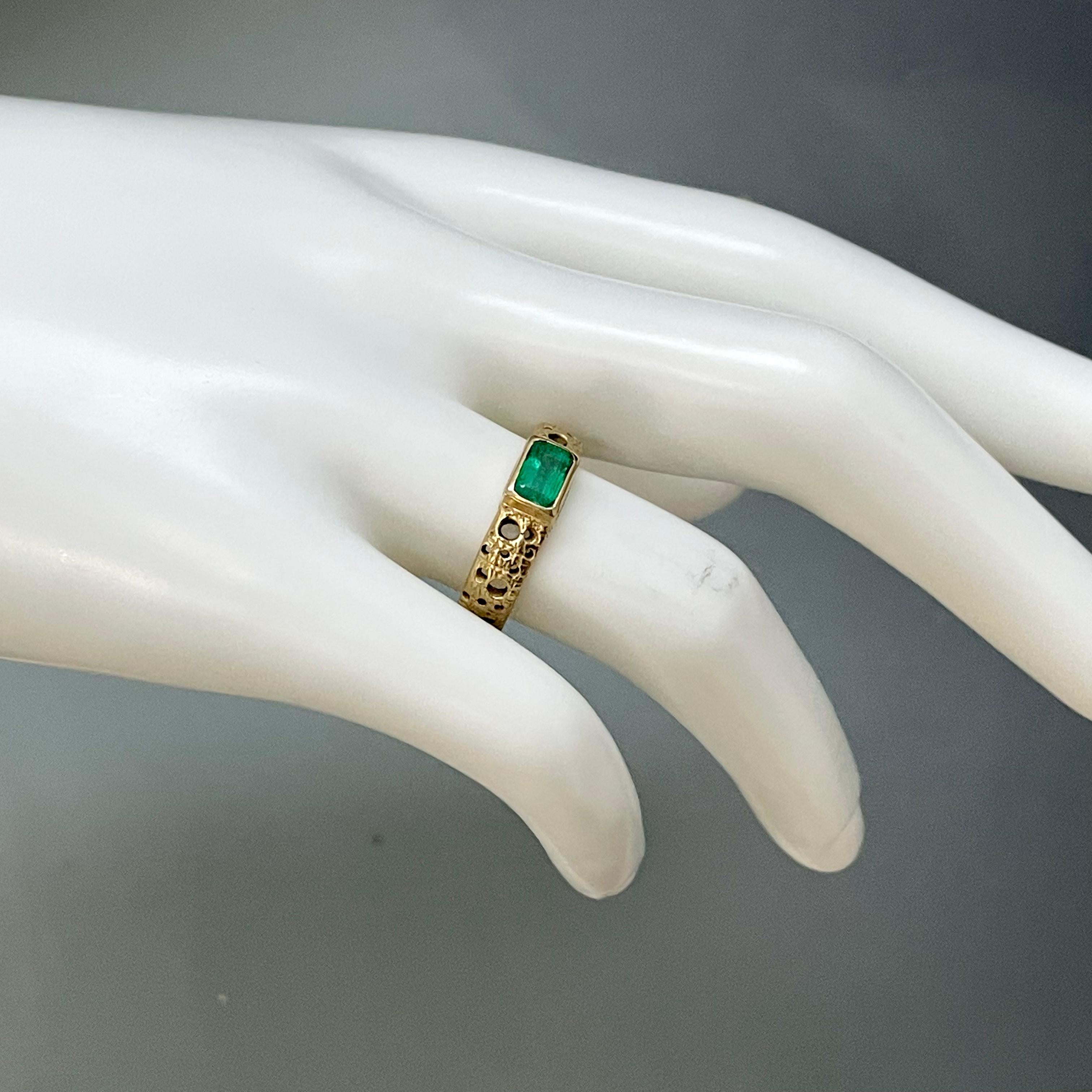 A clear and lively 4 x 6 mm octagon cut emerald is set into an organically carved and textured 18K shank in this unique design.  This ring is currently sized 7.5.  It would be difficult to size up.  Sizing down could be possible.