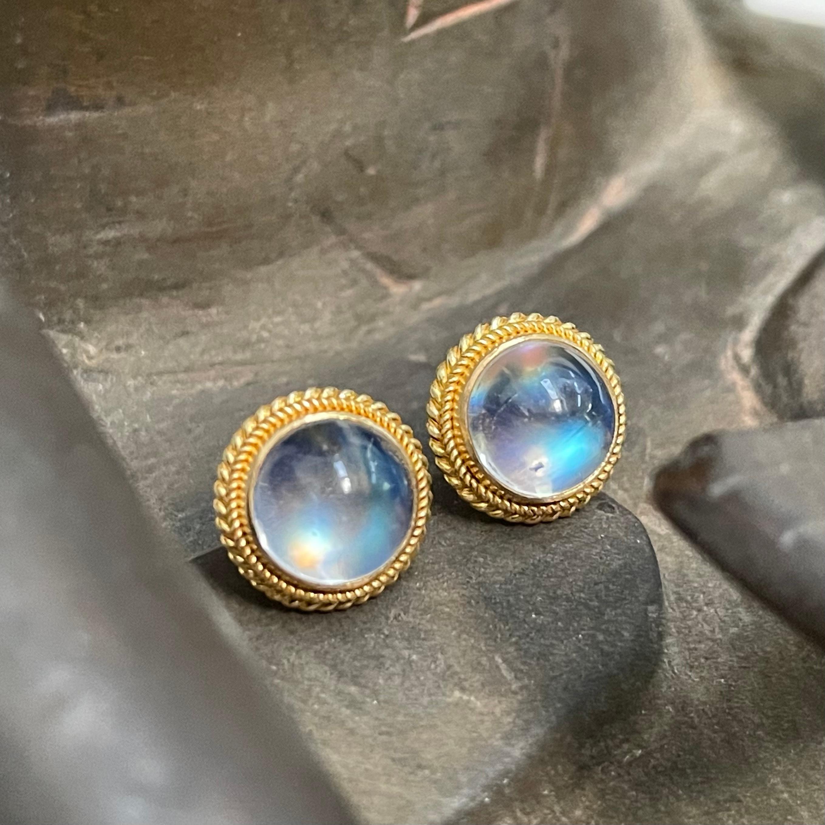 Two 7 mm blue shimmering rainbow moonstone cabochons are held by rich double twist wire ornamentation in this Steven Battelle post earring design.  Elegant, understated, and classy.