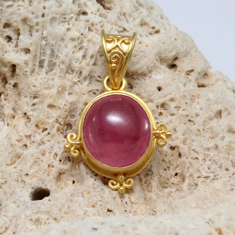 Un luminoso rubí cabujón ovalado rosa de 9 x 10 mm está engastado en un engaste artesanal de 
