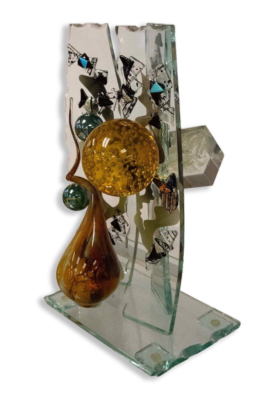 A whimsical and intriguing abstract fused and blown glass assemblage sculpture depicting unique modern forms by glass artist Steve Brewster. Dimensions: 11