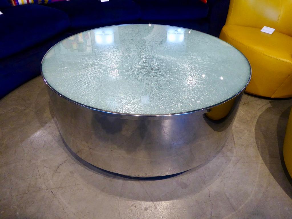 A dramatic and glamorous back-lit, circular polished steel coffee or cocktail table with a triple layer crackled glass transparent top. The table was acquired from a Steve Chase designed home in Rancho Mirage, CA.
The wiring for the light source