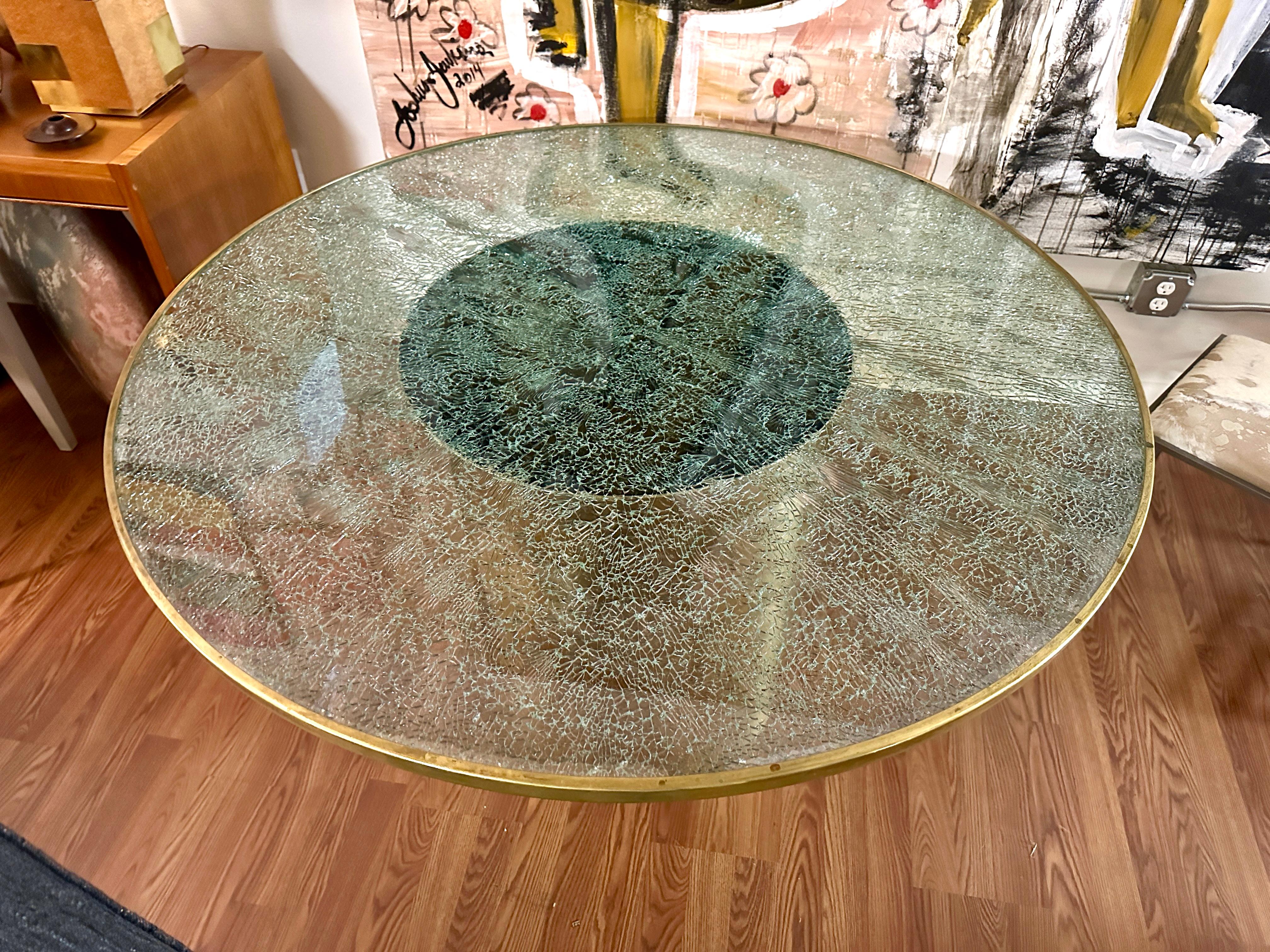 Une belle table de salle à manger conçue par Steve Chase pour une maison de Palm Springs.
Il se caractérise par un plateau en émail craquelé et une base cylindrique en laiton massif.  Le plateau en verre craquelé est orné d'une bordure en laiton. 