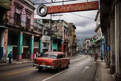 A red car driving through the streets of Havana, Cuba