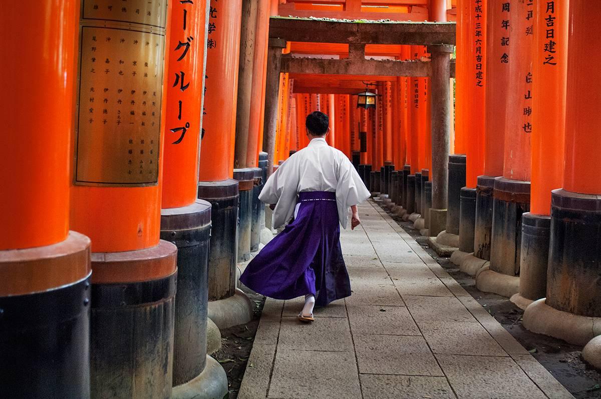 Steve McCurry Color Photograph - Man Walks Through Fushimi Inari Shrine, Kyoto, Japan