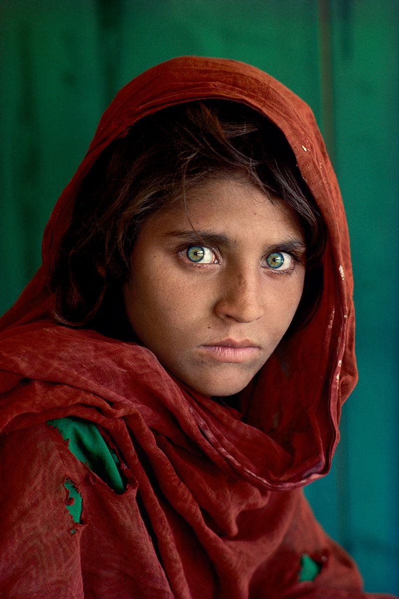 Afghan Girl by Steve McCurry is a 24 x 20 inch digital C-print on Fujiflex Crystal Archive Supergloss paper. One of Steve McCurry's most iconic images, this photograph features a young girl with piercing green eyes wearing a red head scarf. This