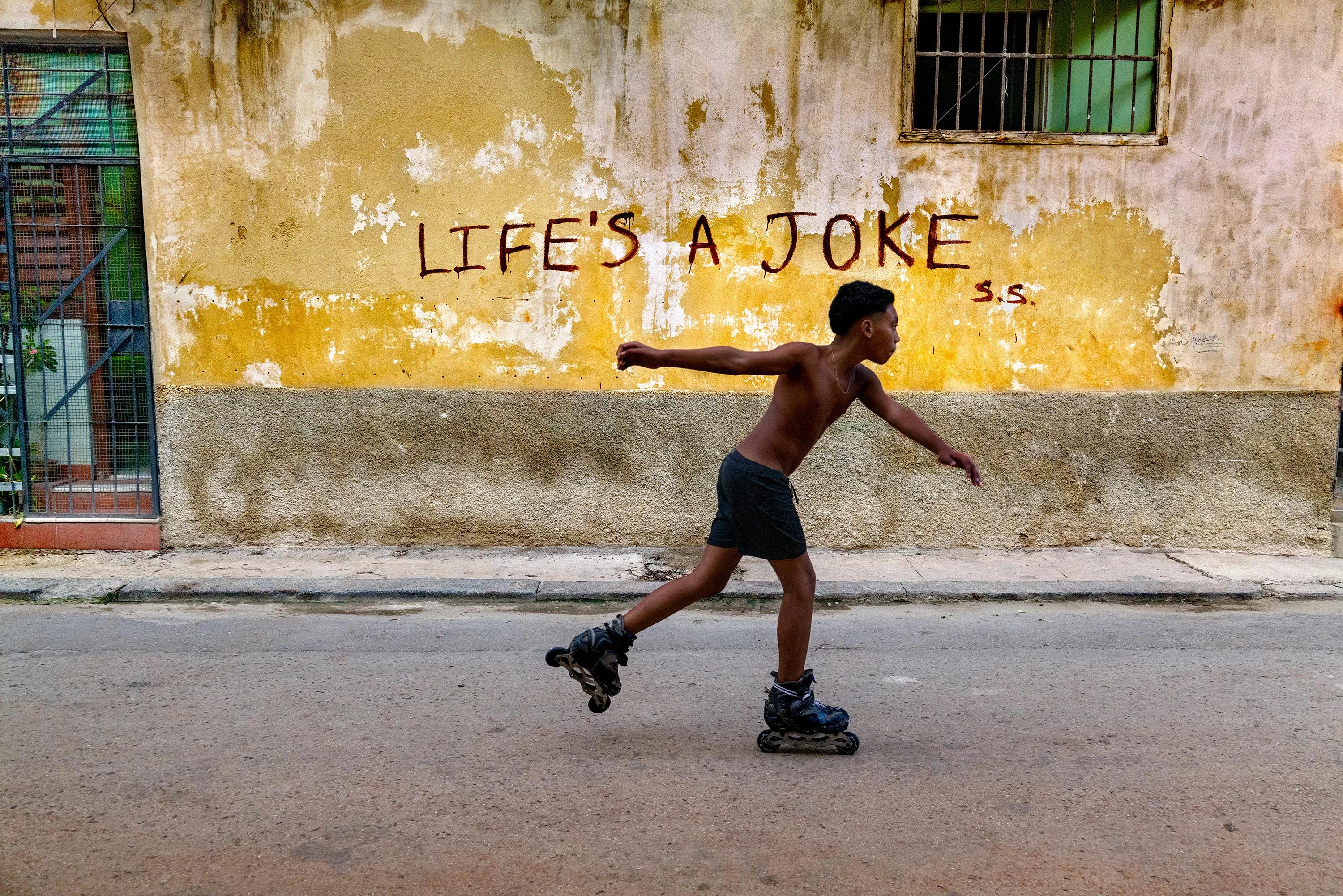 Steve McCurry Landscape Photograph - Boy Rollerskates, Cuba, 2019 "Life's a Joke"