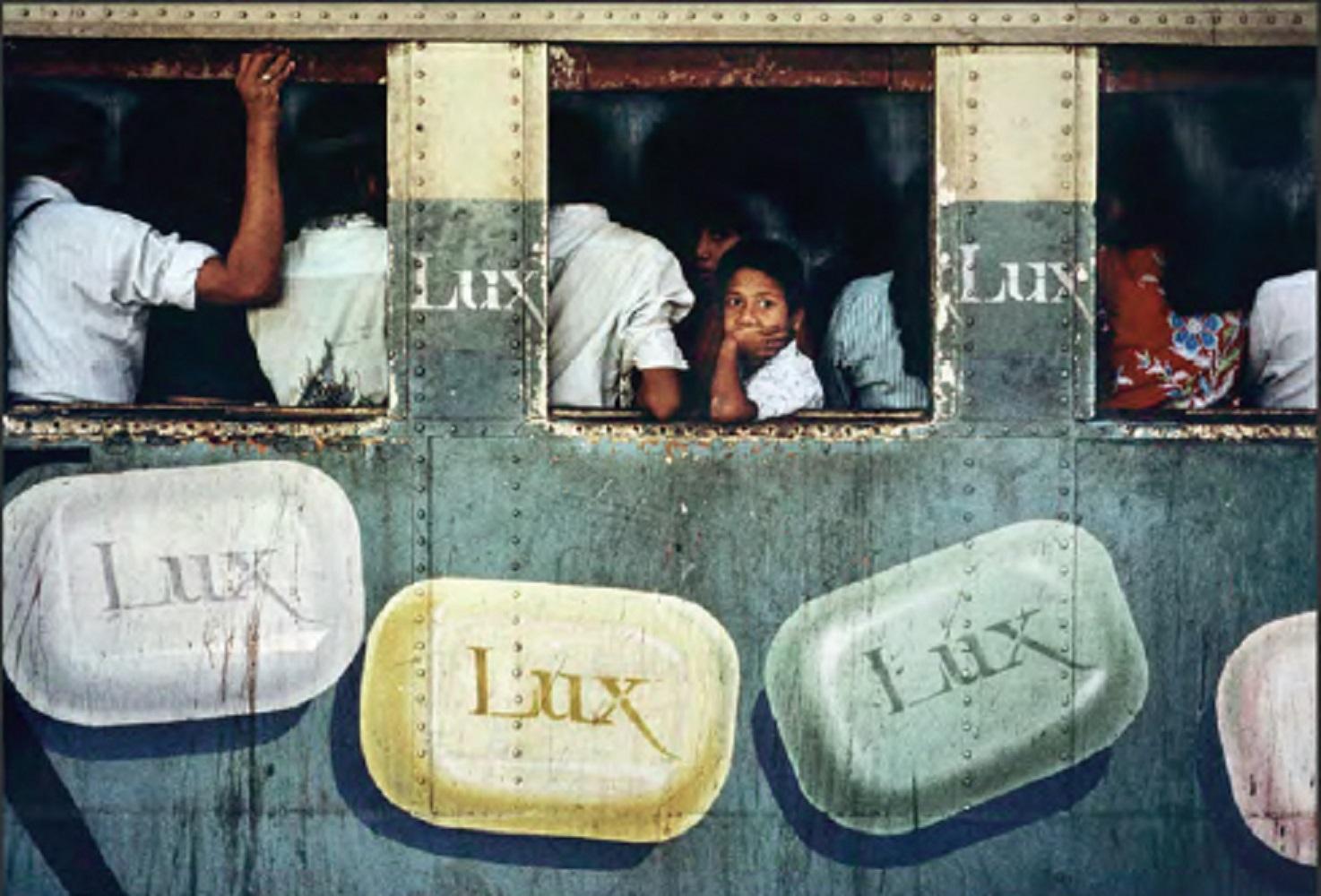 Steve McCurry Color Photograph – Kind schaut aus dem Zugwaggon
